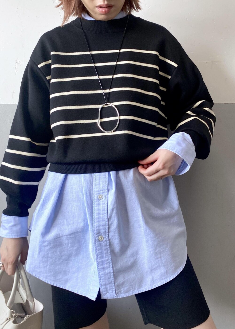 ホワイト系のトートバッグ、ブラック系のニット/セーター、ブルー系のシャツ/ブラウスを着用したレディースの秋コーディネートの9枚目の写真