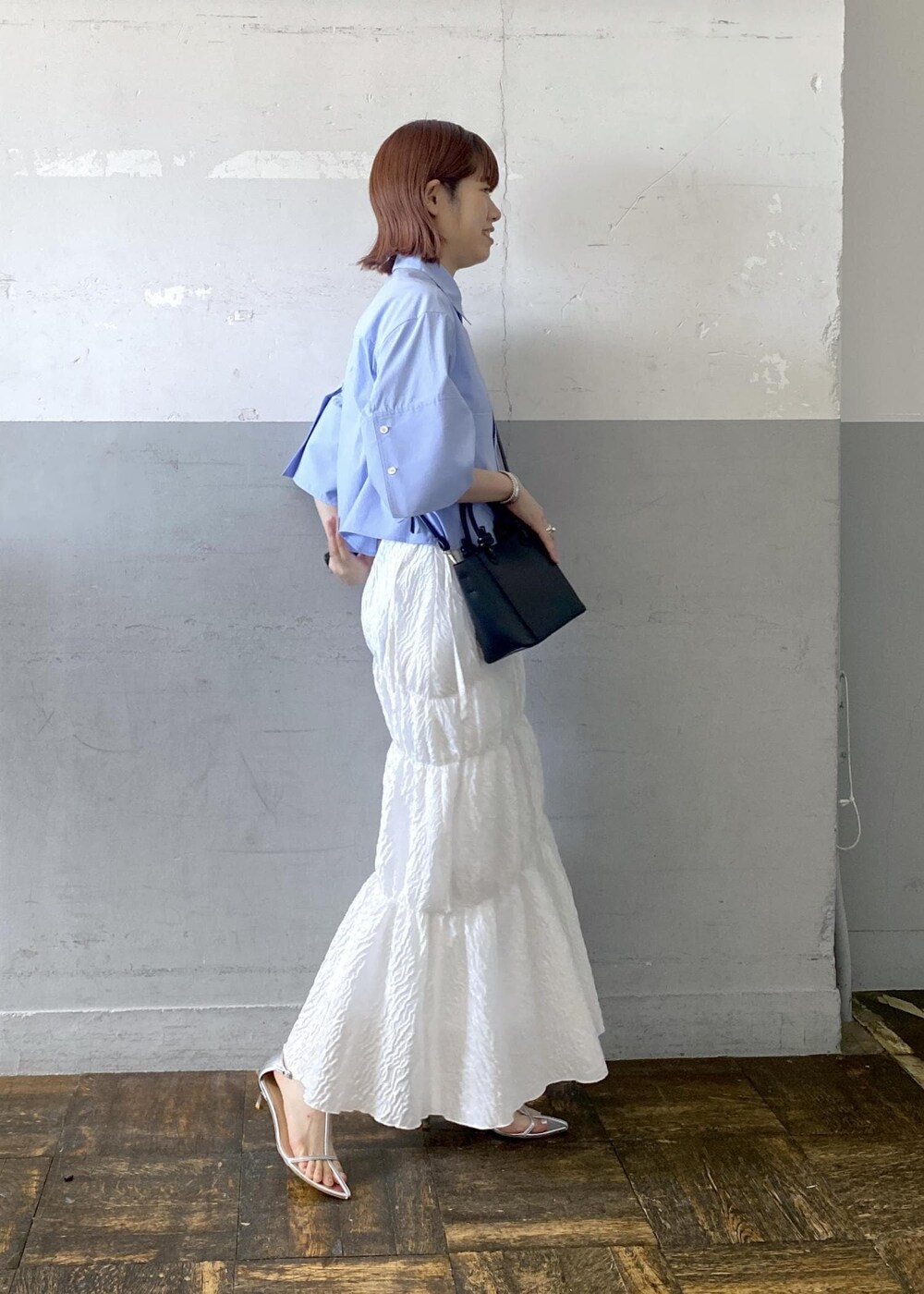 シルバー系のサンダル、ホワイト系のスカート、ブラック系のハンドバッグを着用したレディースの夏コーディネートの3枚目の写真