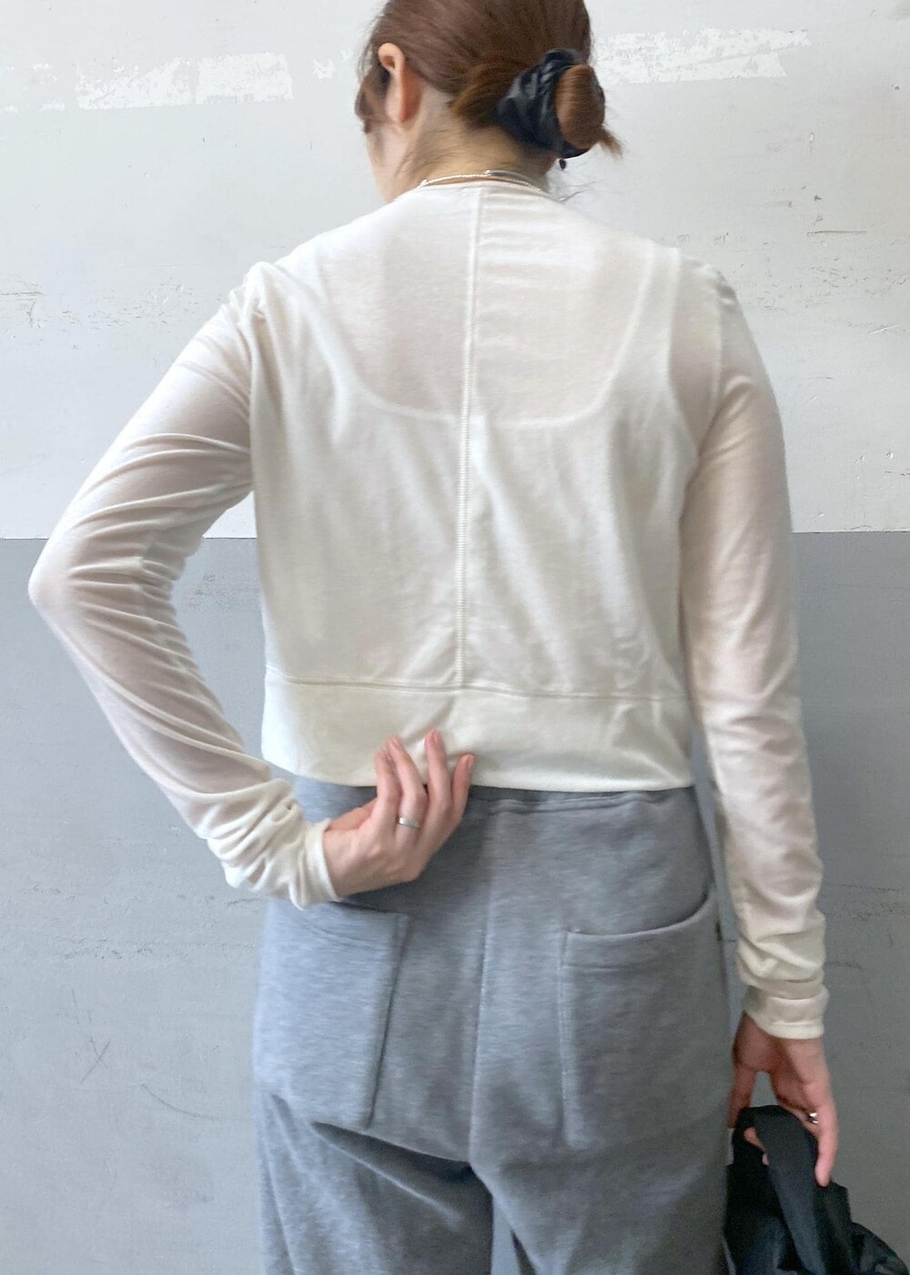 ブラック系のパンプス、ホワイト系のカーディガン/ボレロ、グレー系のスウェットパンツを着用したレディースの秋コーディネートの8枚目の写真