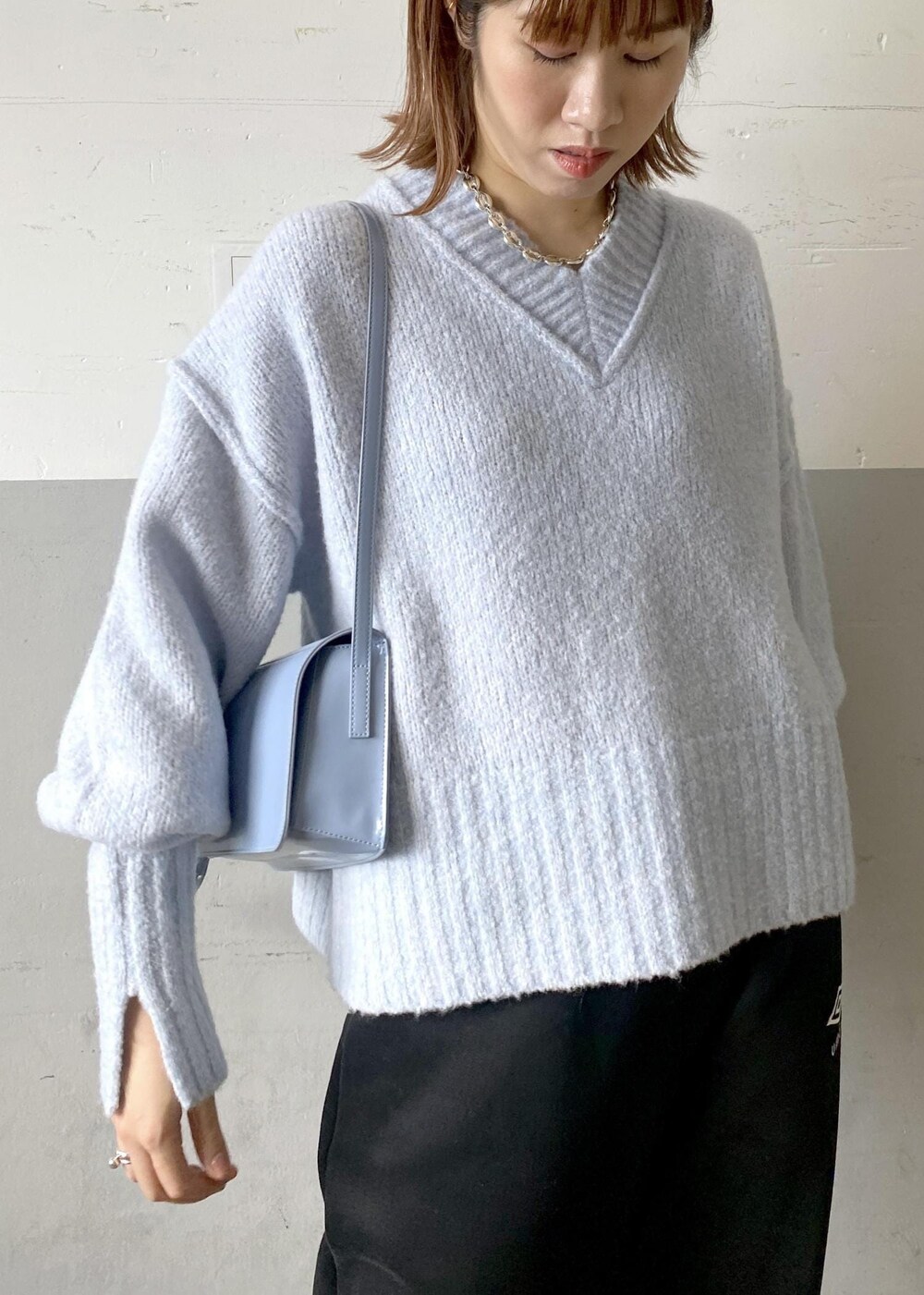 ブルー系のニット/セーター、ブラック系のその他パンツ、ブルー系のショルダーバッグを着用したレディースの秋コーディネートの8枚目の写真