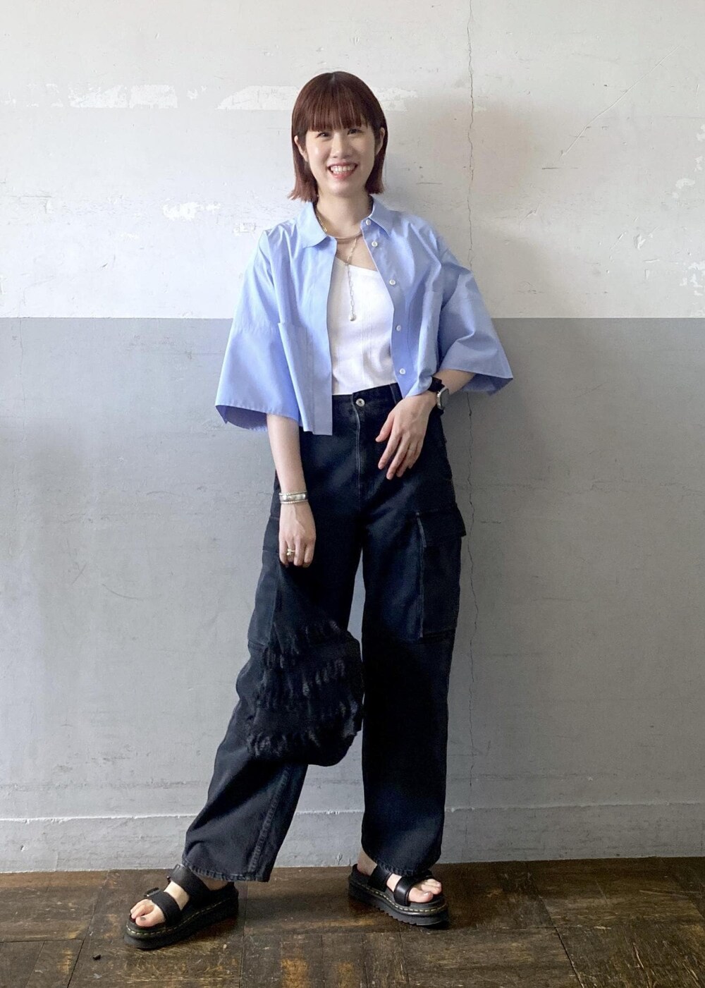 ホワイト系のタンクトップ、ブラック系のカーゴパンツ、ブラック系のトートバッグを着用したレディースの夏コーディネートの2枚目の写真