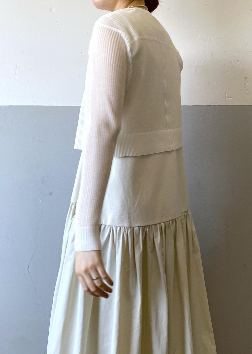 シルバー系のサンダル、ホワイト系のカーディガン/ボレロ、ブラック系のハンドバッグを着用したレディースの夏コーディネートの6枚目の写真