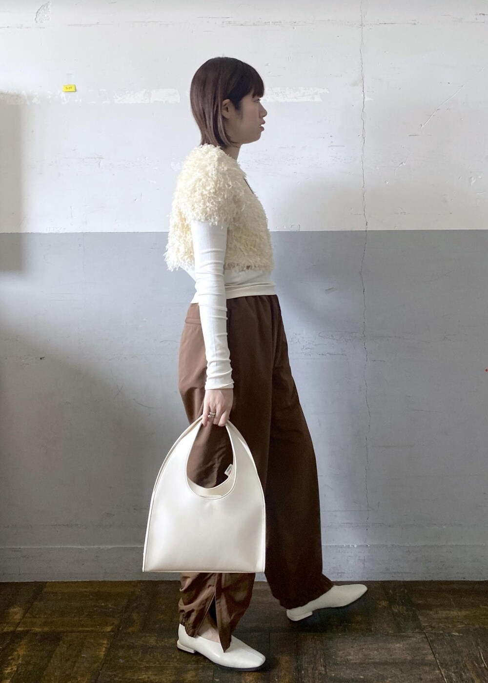 ホワイト系のハンドバッグを着用したレディースの冬コーディネートの5枚目の写真