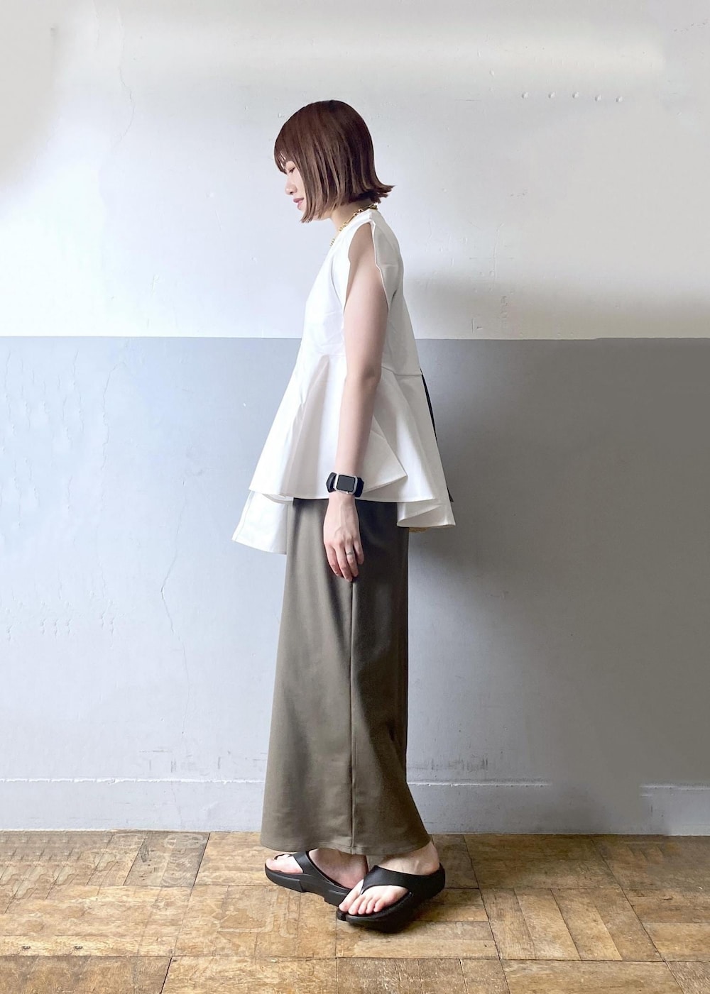 ベージュ系のトートバッグ、グリーン系のワンピース、ホワイト系のTシャツ/カットソーを着用したレディースの夏コーディネートの2枚目の写真