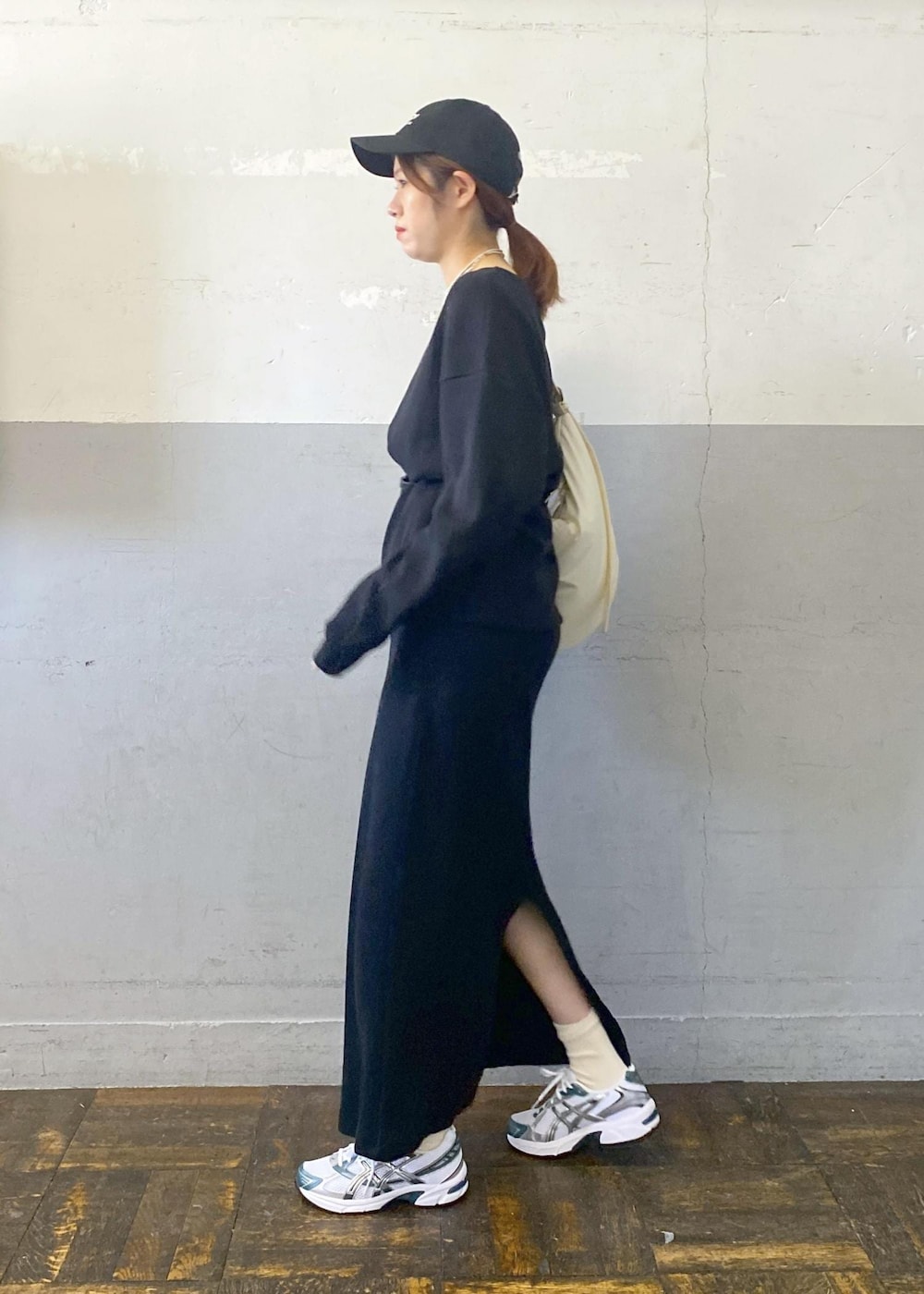 ホワイト系のショルダーバッグ、ブラック系のTシャツ/カットソー、ブラック系のスカートを着用したレディースの秋コーディネートの4枚目の写真