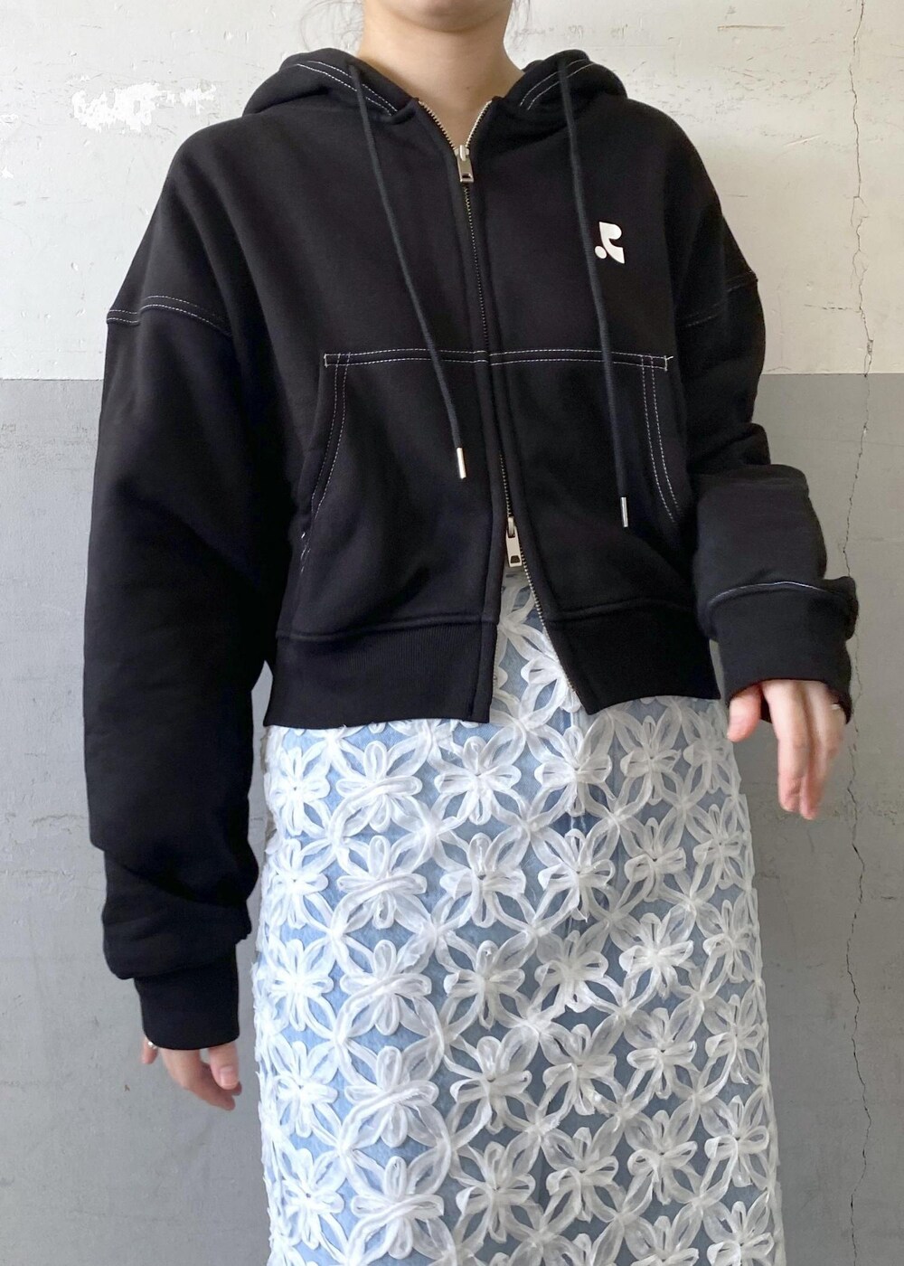 ブラック系のショルダーバッグ、ホワイト系のスカートを着用したレディースの夏コーディネートの7枚目の写真