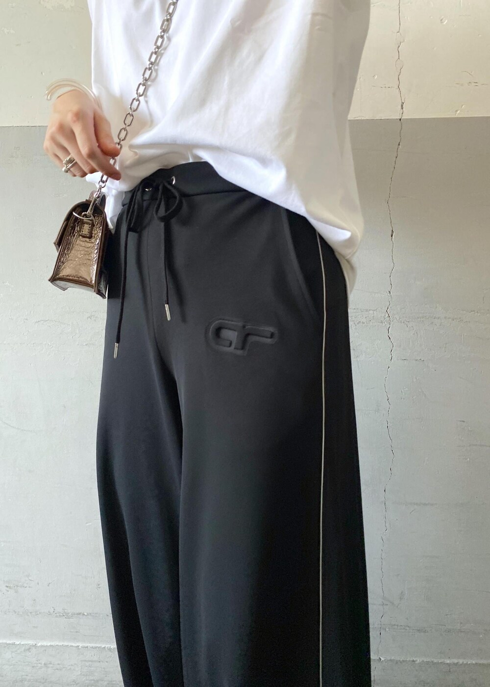 シルバー系のバレエシューズ、ホワイト系のTシャツ/カットソー、その他のショルダーバッグを着用したレディースの夏コーディネートの5枚目の写真