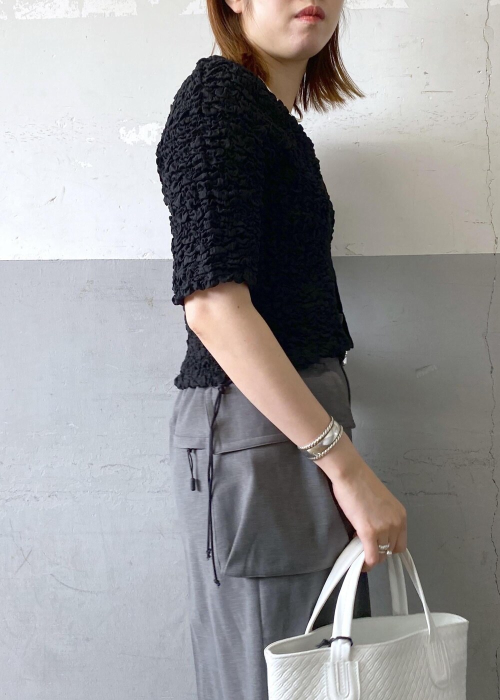 ブラック系のサンダル、ブラック系のカーディガン/ボレロ、ホワイト系のトートバッグを着用したレディースの春コーディネートの6枚目の写真