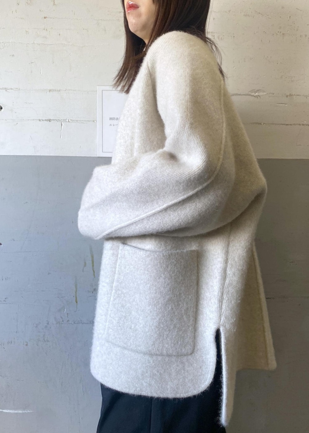 ホワイト系のカーディガン/ボレロ、ホワイト系のニット/セーター、ブラック系のハンドバッグを着用したレディースの冬コーディネートの7枚目の写真