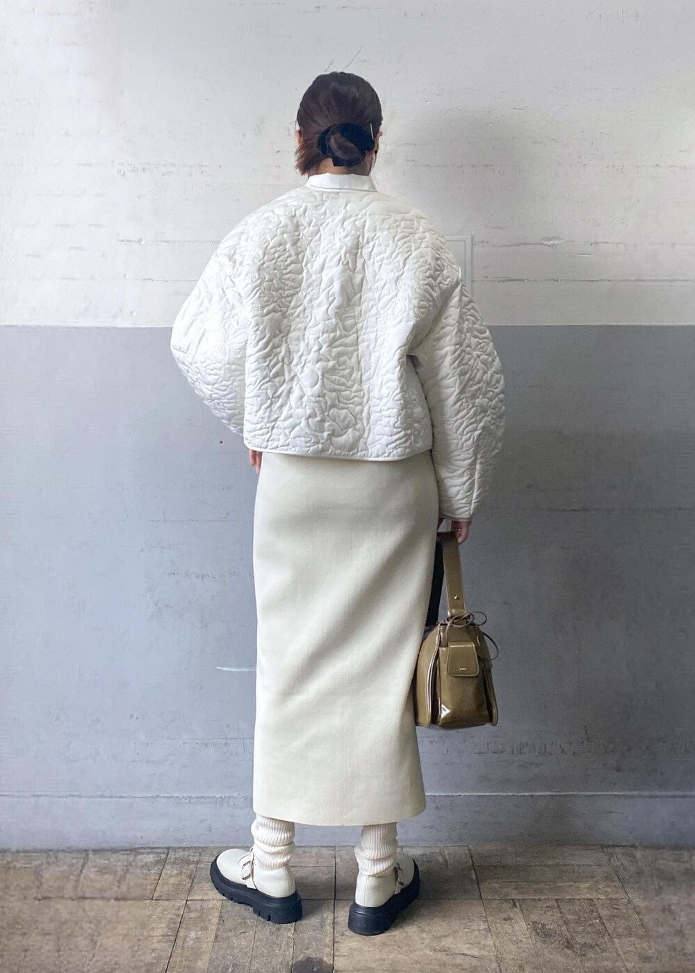 ホワイト系のその他シューズ、ホワイト系のワンピース、ホワイト系のブルゾンを着用したレディースの冬コーディネートの2枚目の写真