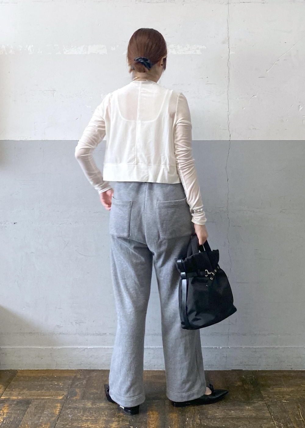 ブラック系のパンプス、ホワイト系のカーディガン/ボレロ、グレー系のスウェットパンツを着用したレディースの秋コーディネートの3枚目の写真
