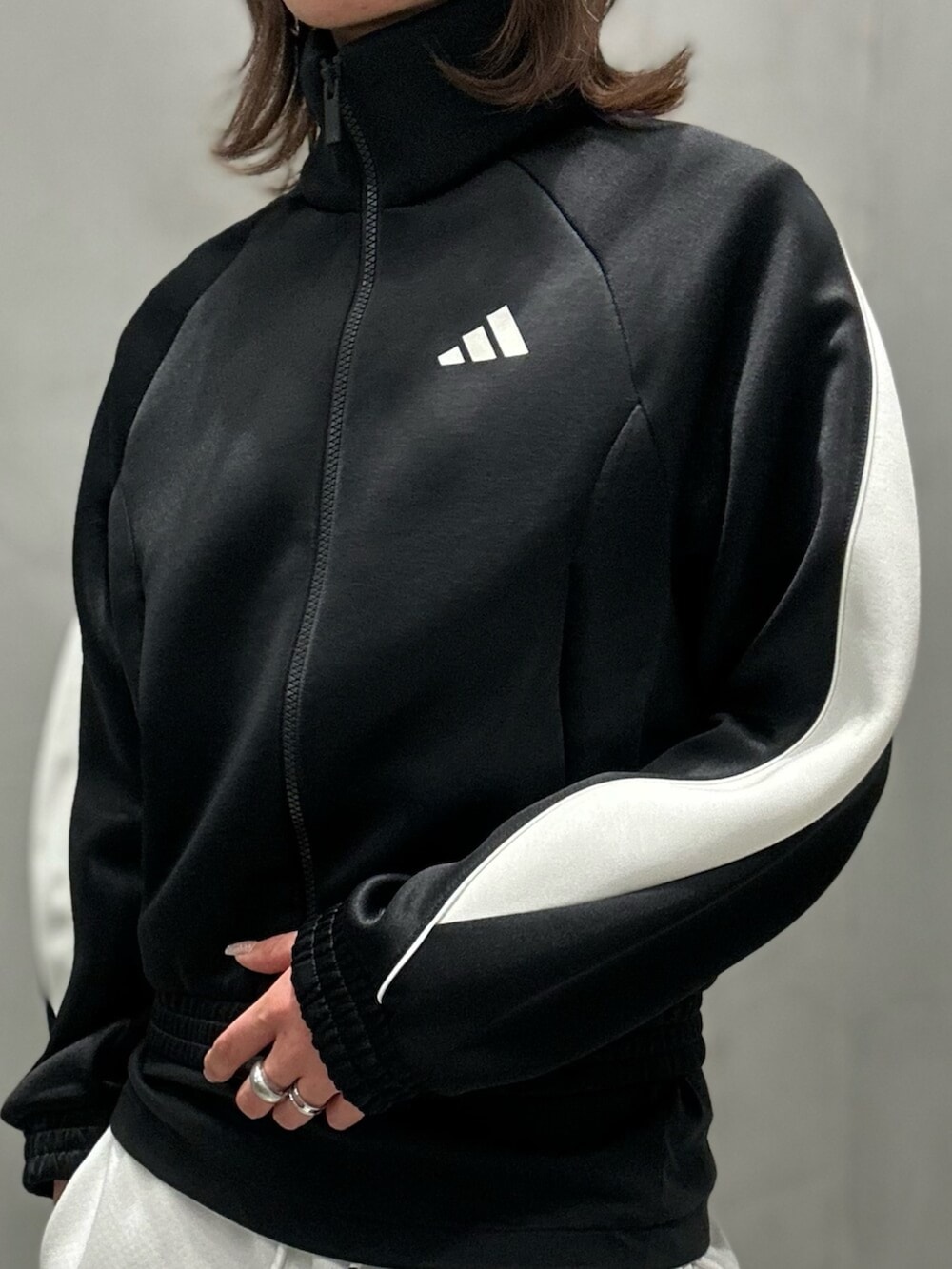 ブラック系のジャージ、ブラック系のスウェットパンツ、ホワイト系のシューズを着用したレディースの秋コーディネートの7枚目の写真