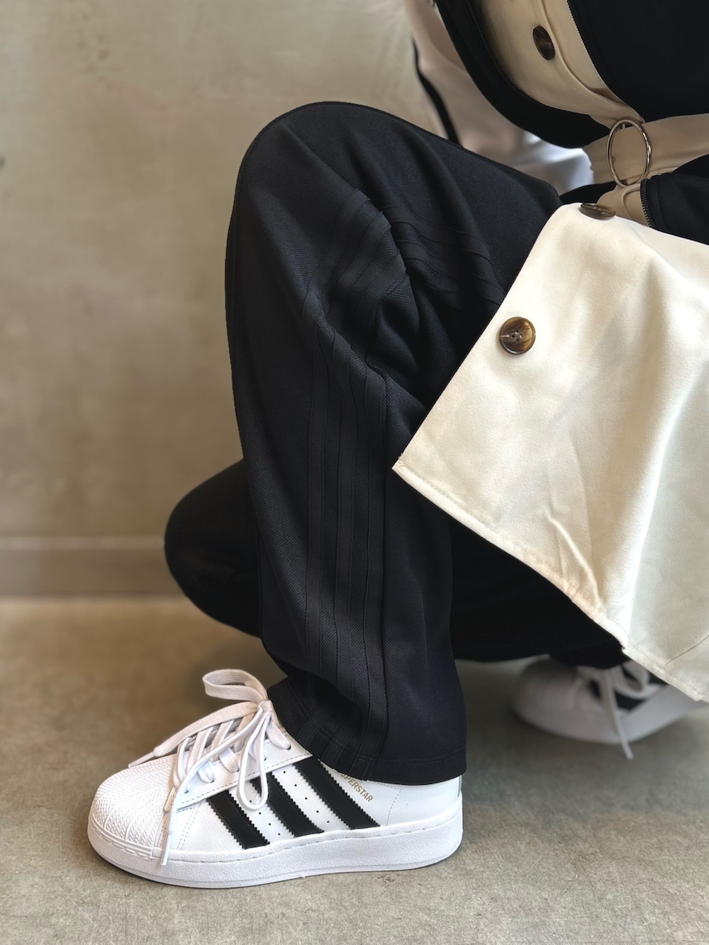 ブラック系のジャージ、ブラック系のスウェットパンツ、ホワイト系のスニーカーを着用したレディースの夏コーディネートの5枚目の写真