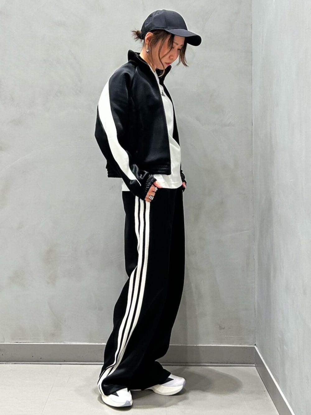 ブラック系のジャージ、ブラック系のスウェットパンツ、ホワイト系のシューズを着用したレディースの秋コーディネートの3枚目の写真