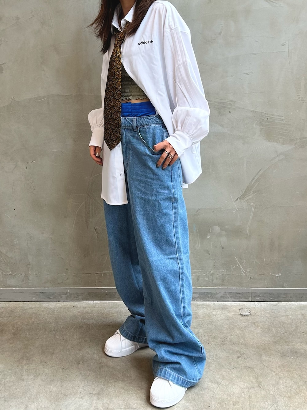 ホワイト系のスニーカー、ブラック系のショルダーバッグ、ホワイト系のTシャツ/カットソーを着用したレディースの夏コーディネートの3枚目の写真