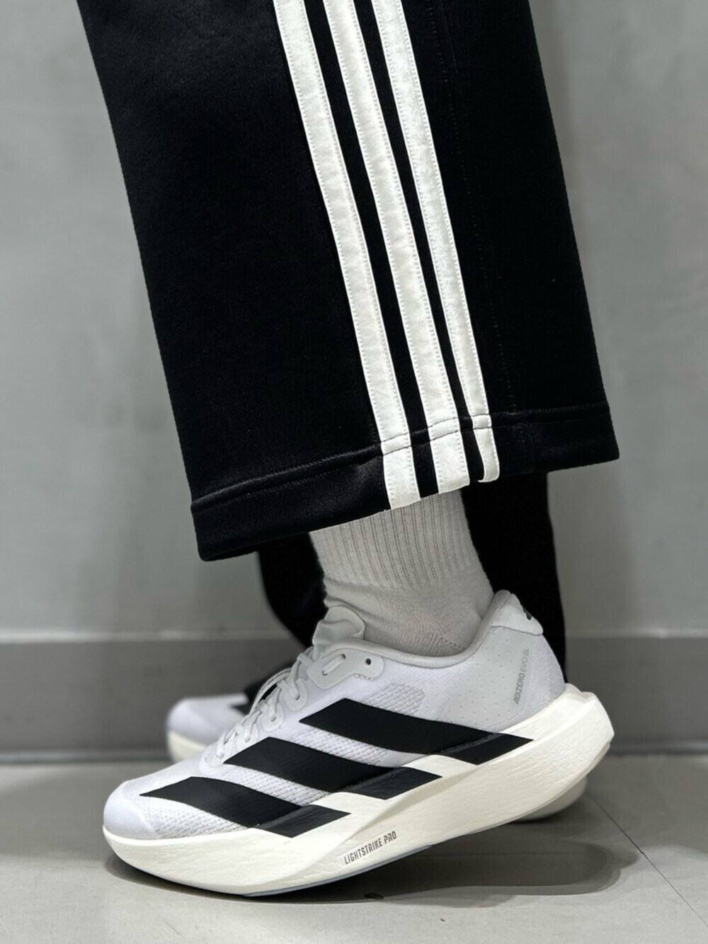 ブラック系のジャージ、ブラック系のスウェットパンツ、ホワイト系のシューズを着用したレディースの秋コーディネートの10枚目の写真