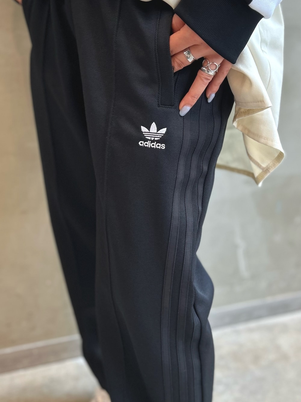 ブラック系のジャージ、ブラック系のスウェットパンツ、ホワイト系のスニーカーを着用したレディースの夏コーディネートの4枚目の写真