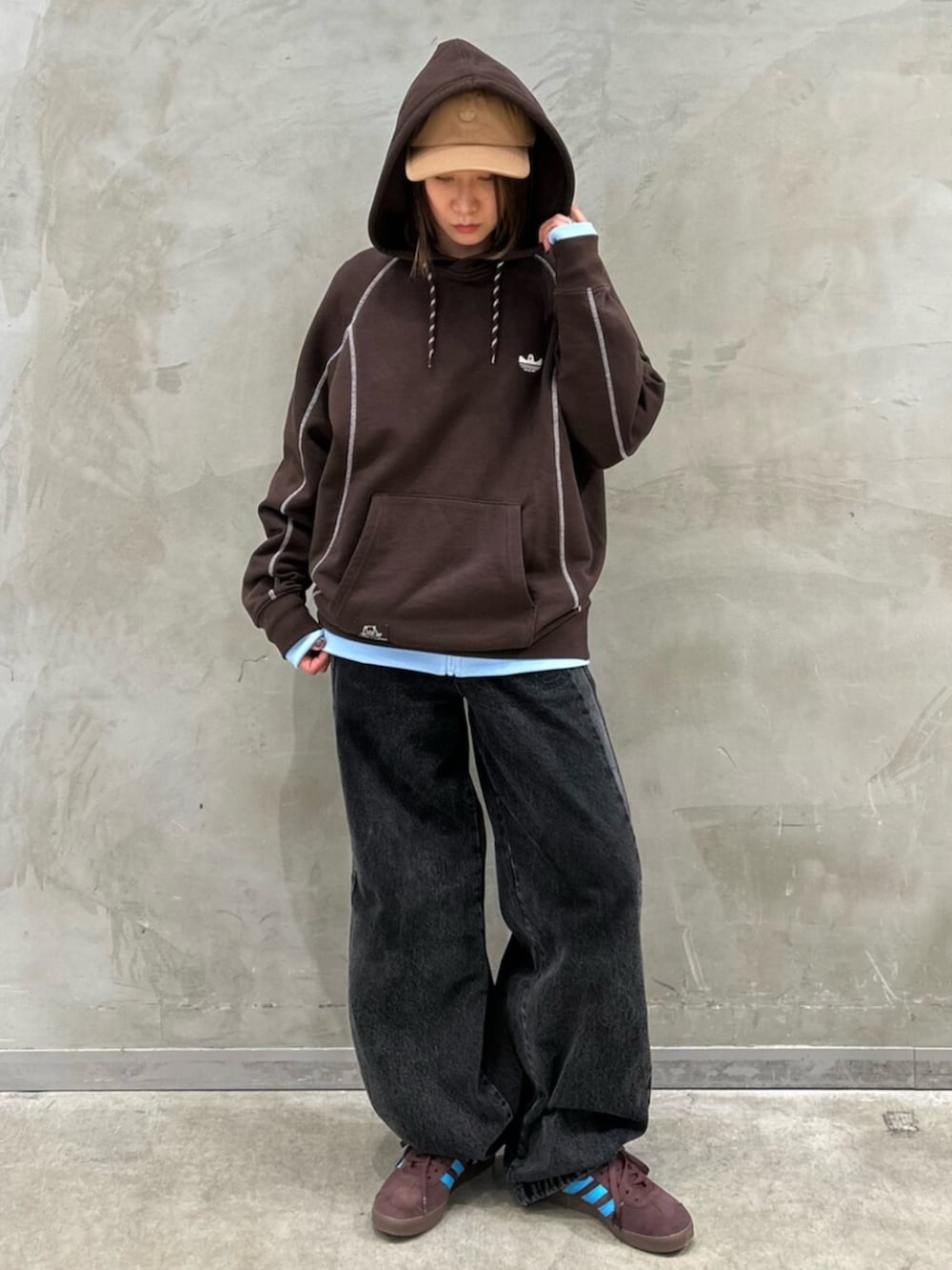 ブラック系のパンツ、ブラウン系のスニーカー、ブラウン系のパーカーを着用したレディースの冬コーディネートの2枚目の写真