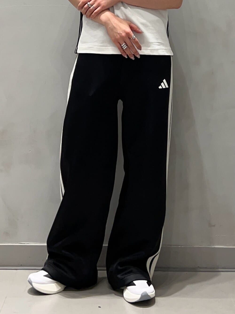 ブラック系のジャージ、ブラック系のスウェットパンツ、ホワイト系のシューズを着用したレディースの秋コーディネートの9枚目の写真