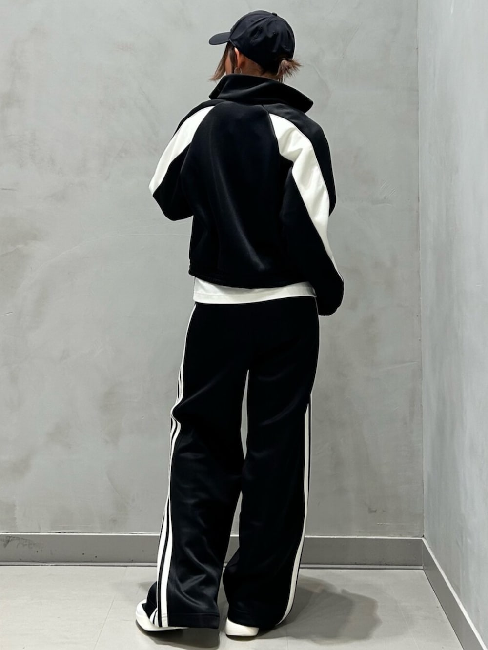 ブラック系のジャージ、ブラック系のスウェットパンツ、ホワイト系のシューズを着用したレディースの秋コーディネートの4枚目の写真