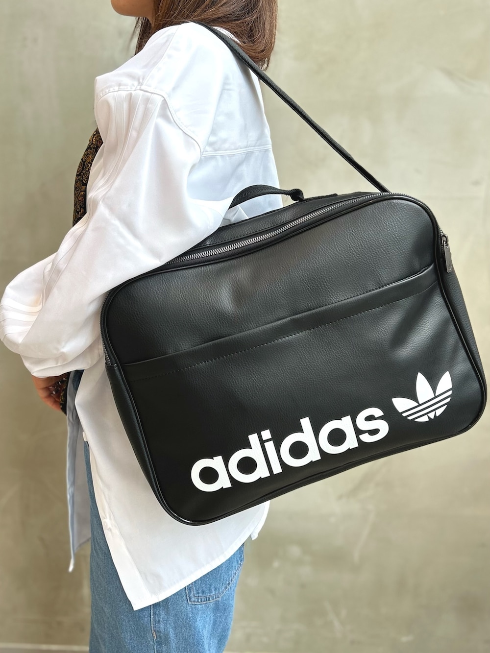 ホワイト系のスニーカー、ブラック系のショルダーバッグ、ホワイト系のTシャツ/カットソーを着用したレディースの夏コーディネートの2枚目の写真