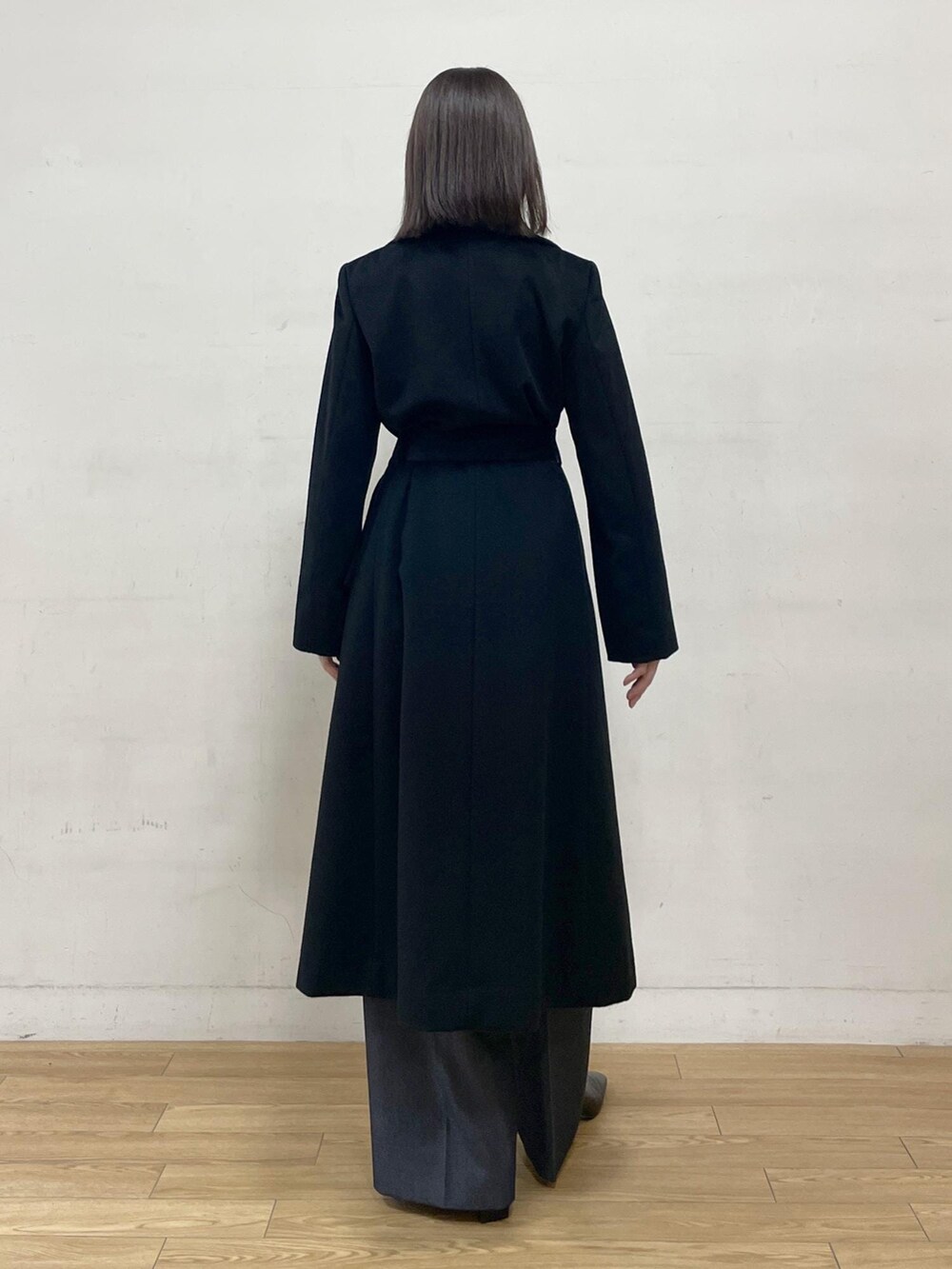 ブラック系のブーツ、ブラック系のステンカラーコート、ブルー系のその他パンツを着用したレディースの秋コーディネートの6枚目の写真