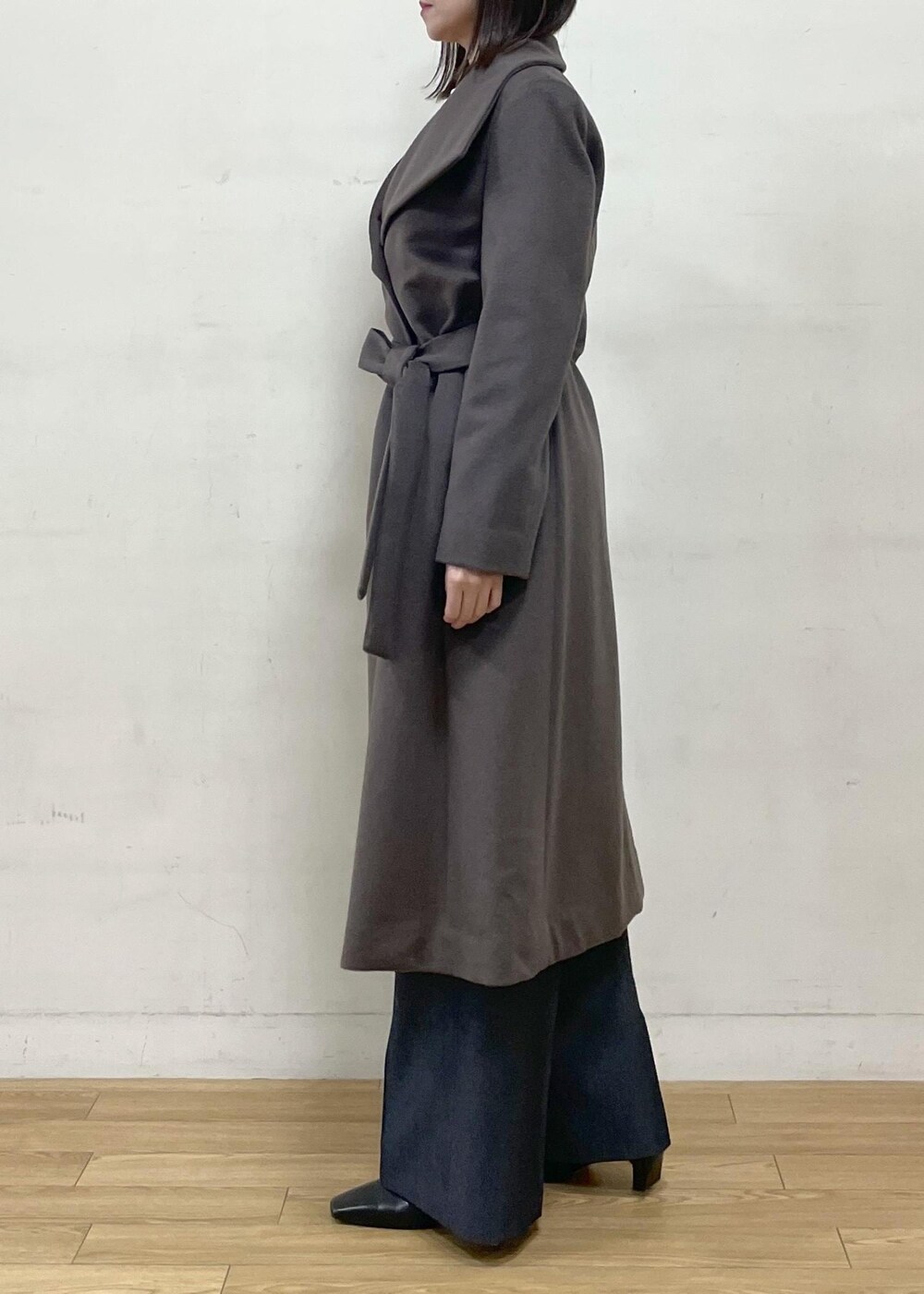 ブラック系のブーツ、ブラウン系のステンカラーコート、ブルー系のその他パンツを着用したレディースの秋コーディネートの4枚目の写真