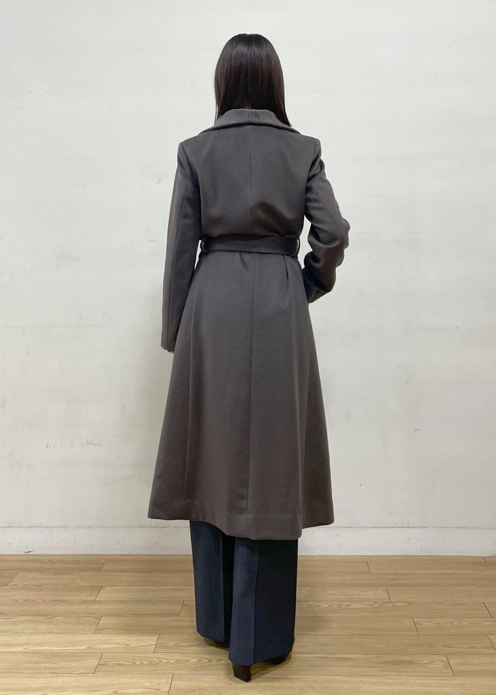 ブラック系のブーツ、ブラウン系のステンカラーコート、ブルー系のその他パンツを着用したレディースの秋コーディネートの5枚目の写真