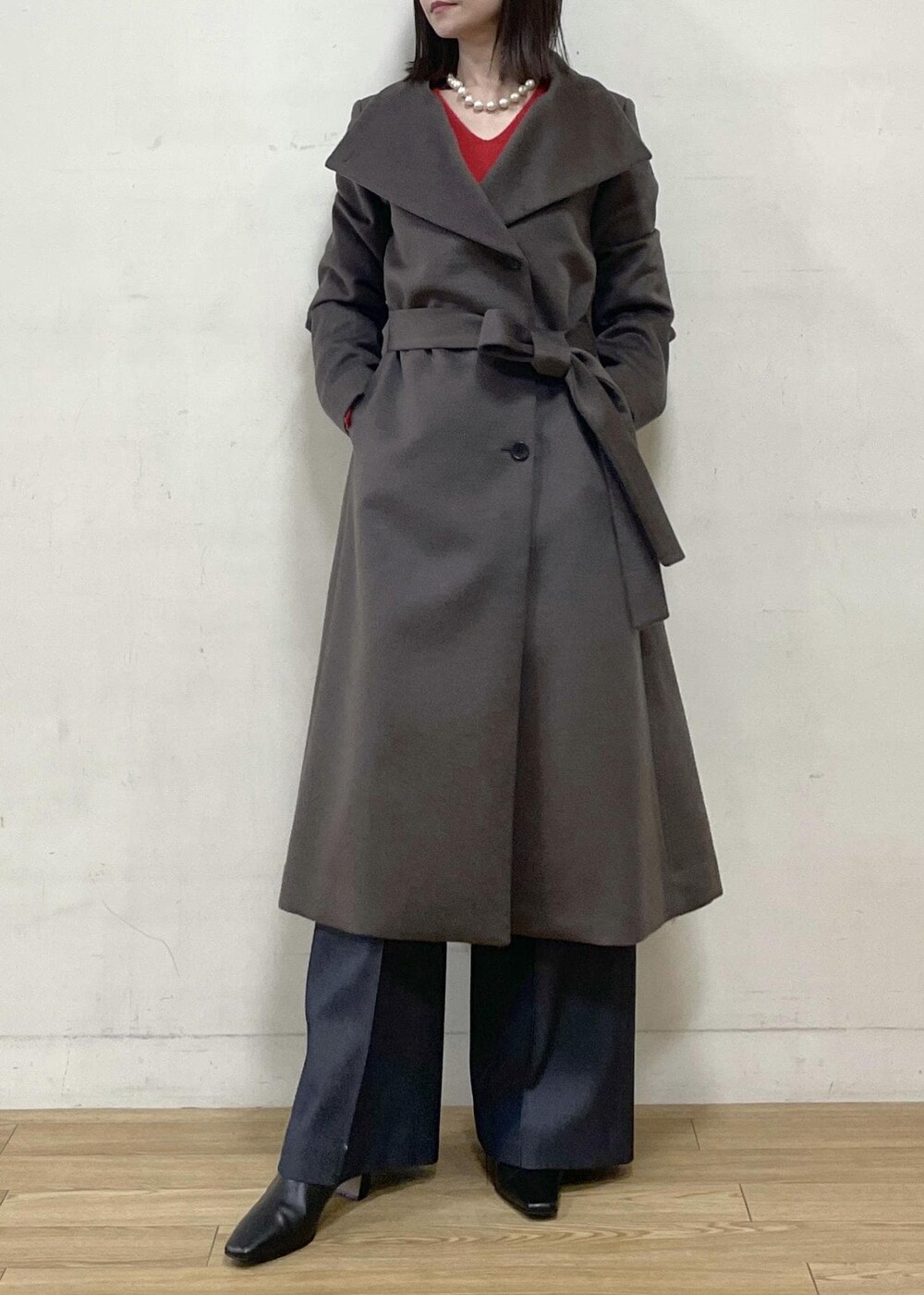 ブラック系のブーツ、ブラウン系のステンカラーコート、ブルー系のその他パンツを着用したレディースの秋コーディネートの3枚目の写真