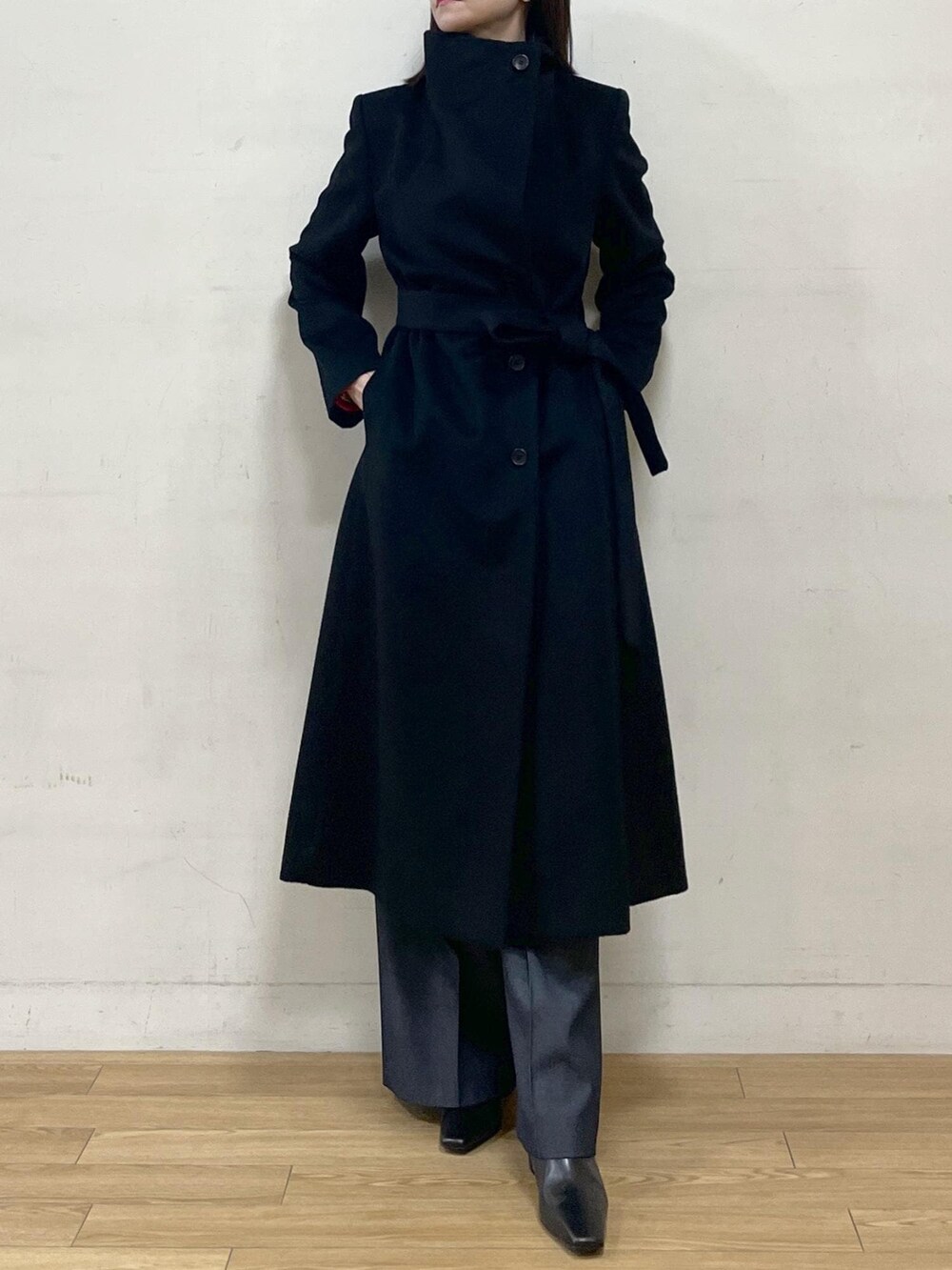 ブラック系のブーツ、ブラック系のステンカラーコート、ブルー系のその他パンツを着用したレディースの秋コーディネートの8枚目の写真