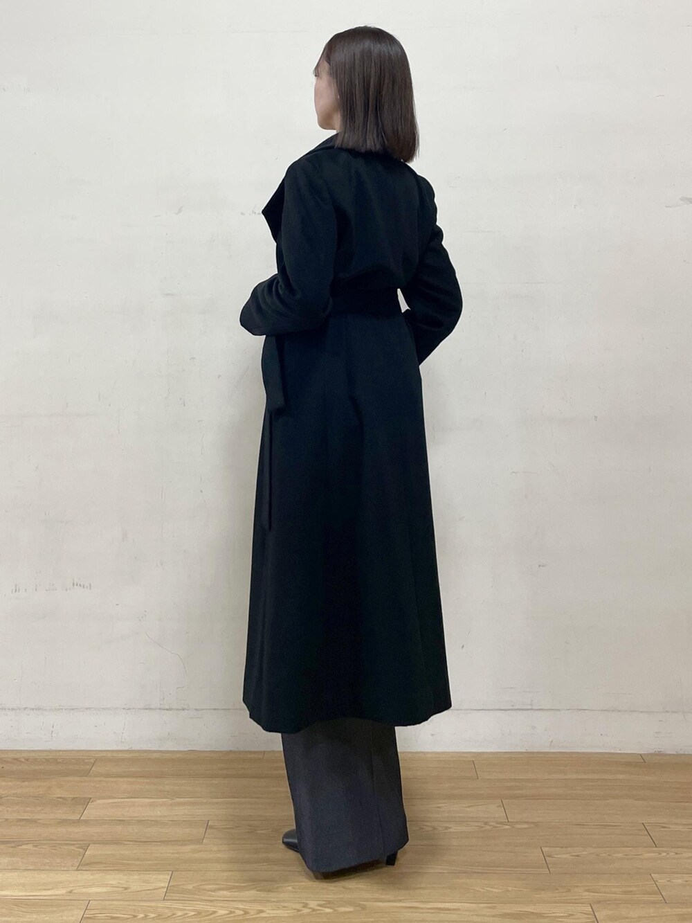 ブラック系のブーツ、ブラック系のステンカラーコート、ブルー系のその他パンツを着用したレディースの秋コーディネートの5枚目の写真