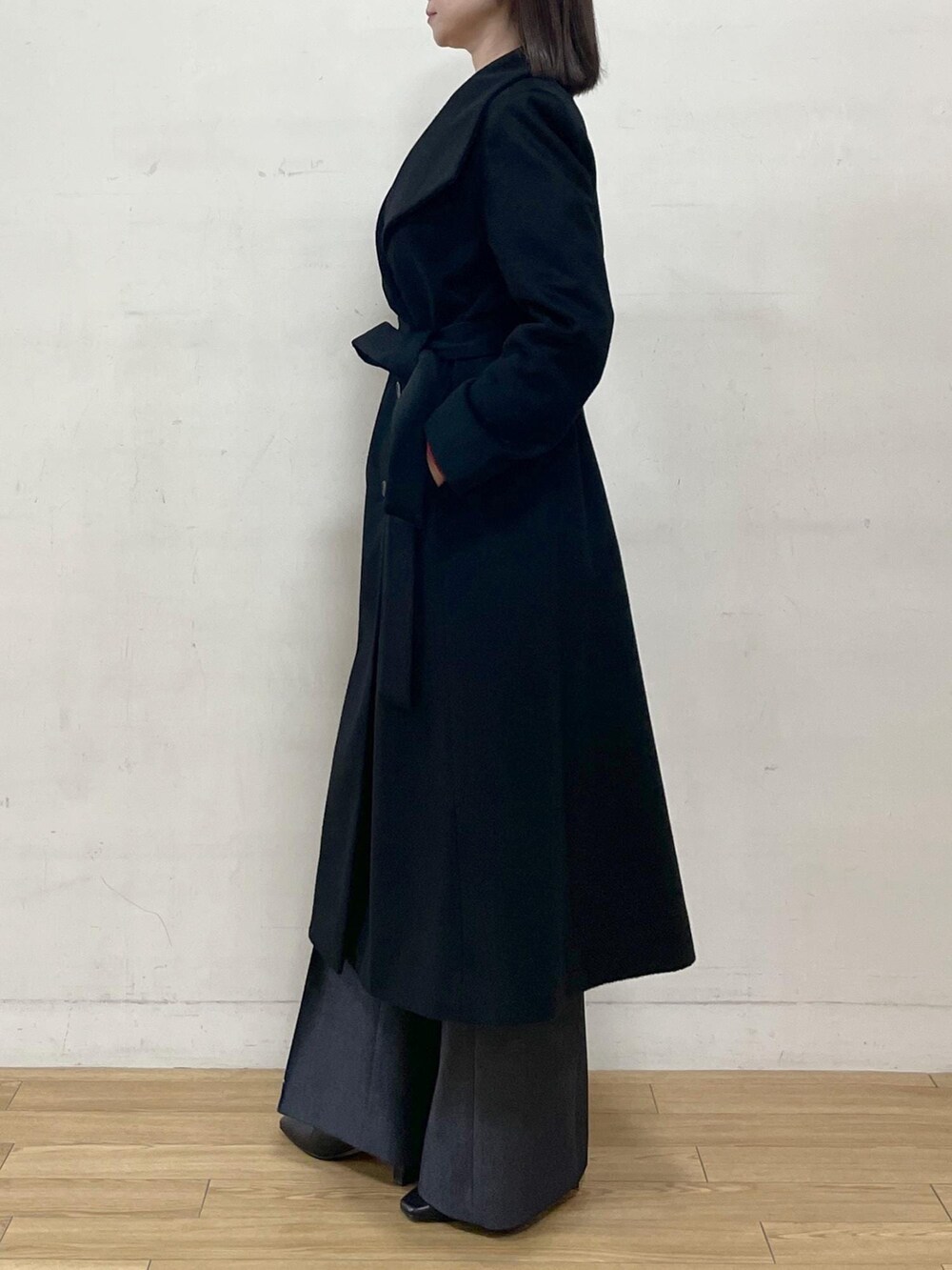 ブラック系のブーツ、ブラック系のステンカラーコート、ブルー系のその他パンツを着用したレディースの秋コーディネートの4枚目の写真