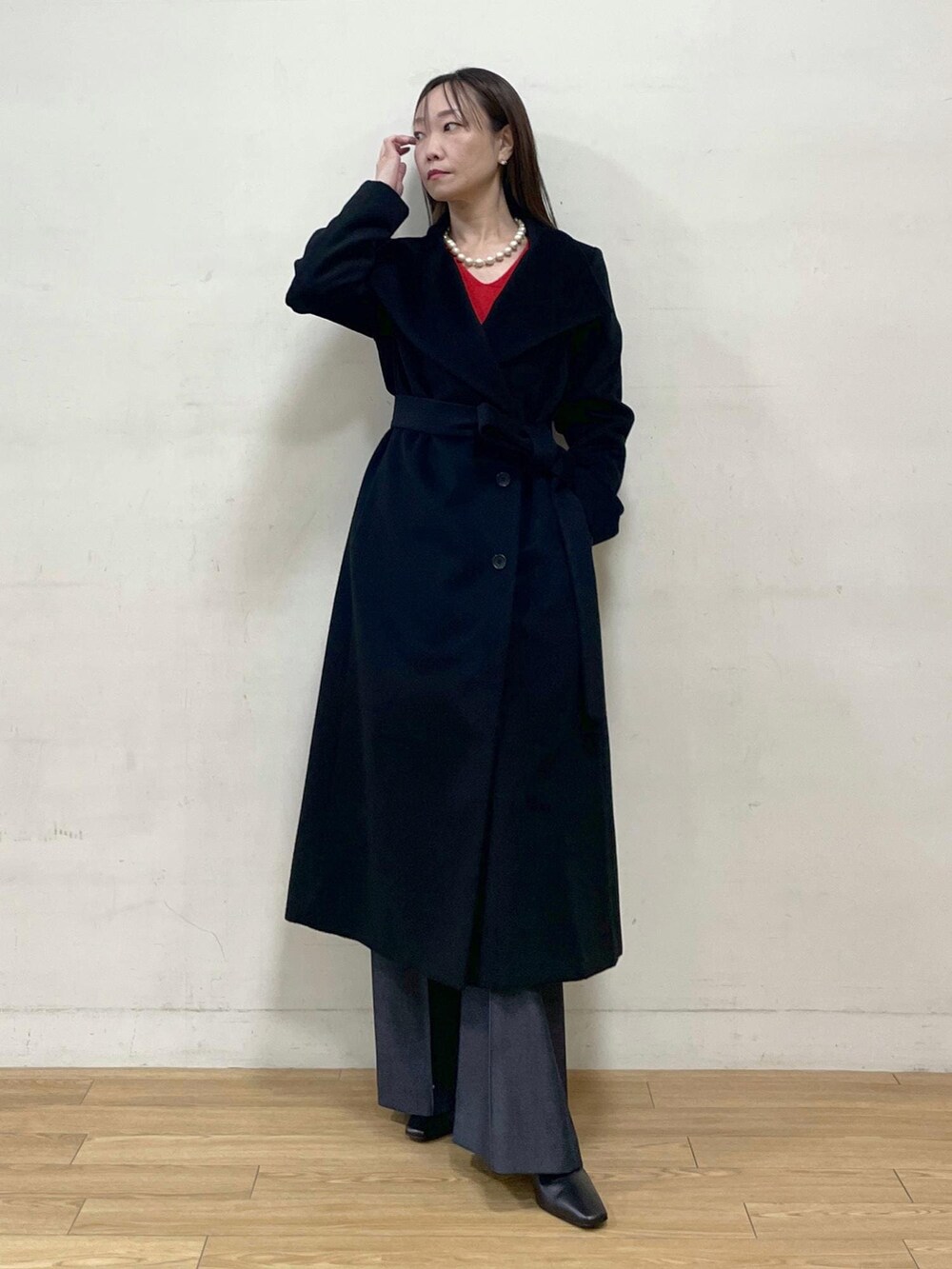 ブラック系のブーツ、ブラック系のステンカラーコート、ブルー系のその他パンツを着用したレディースの秋コーディネートの2枚目の写真