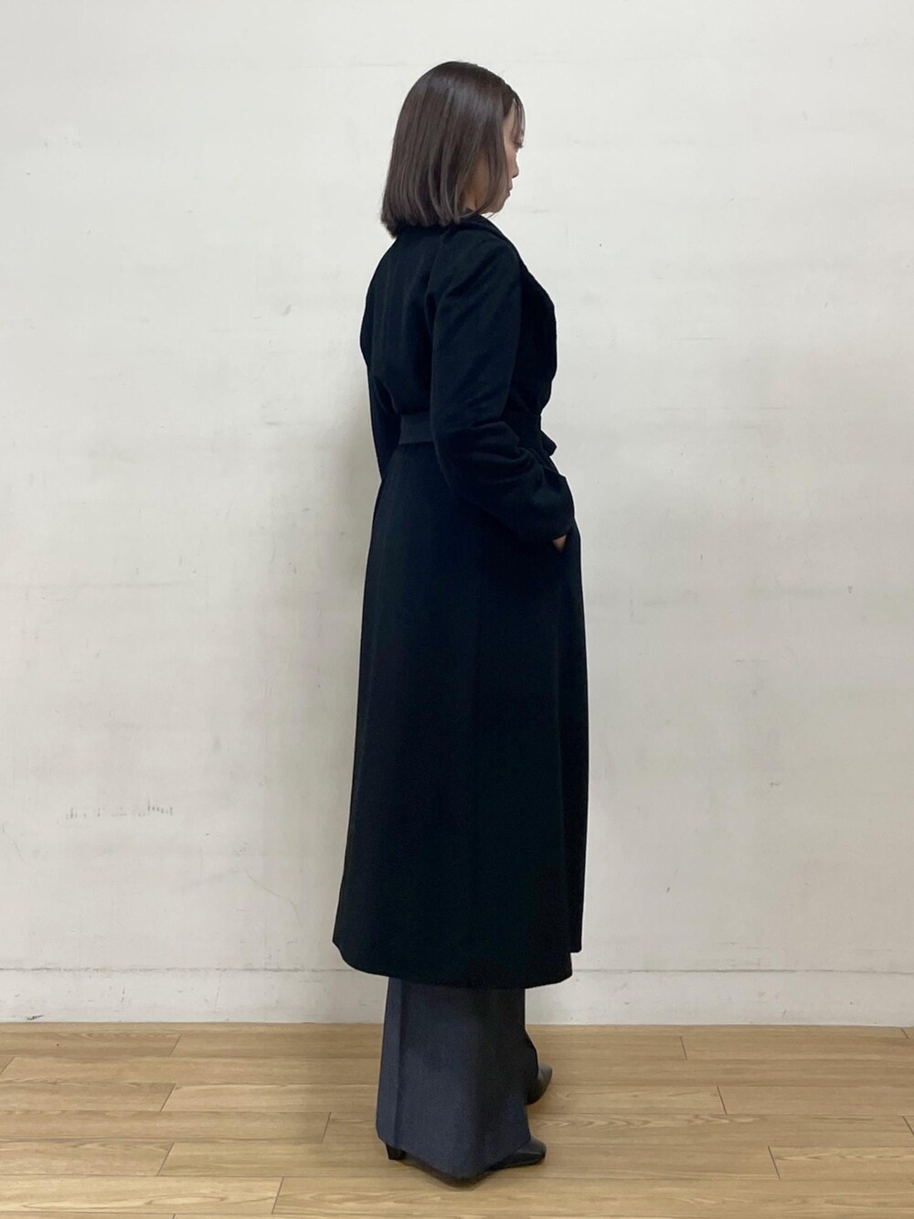 ブラック系のブーツ、ブラック系のステンカラーコート、ブルー系のその他パンツを着用したレディースの秋コーディネートの7枚目の写真