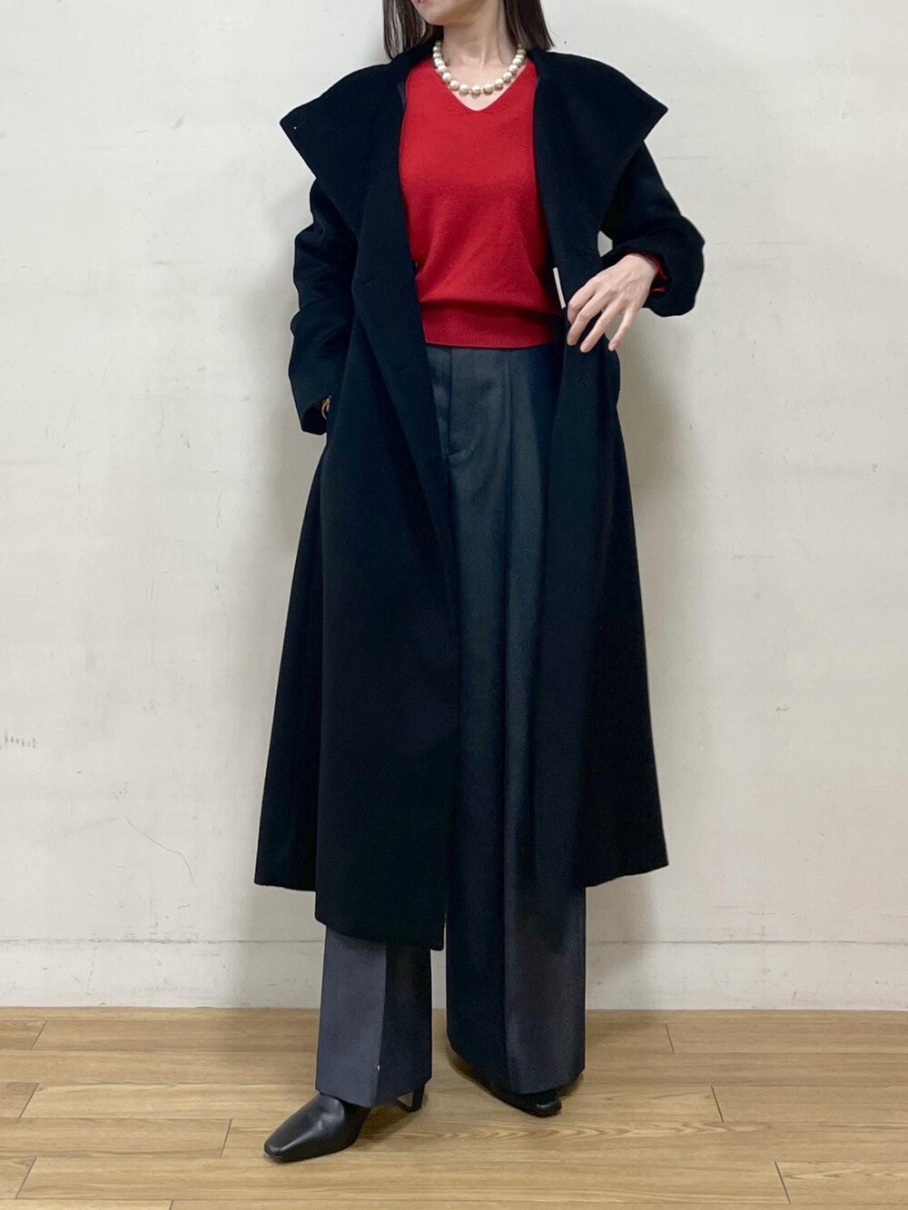 ブラック系のブーツ、ブラック系のステンカラーコート、ブルー系のその他パンツを着用したレディースの秋コーディネートの3枚目の写真