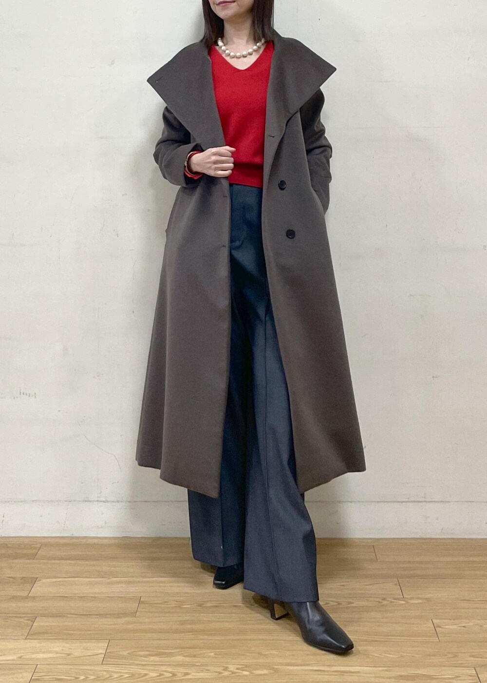 ブラック系のブーツ、ブラウン系のステンカラーコート、ブルー系のその他パンツを着用したレディースの秋コーディネートの9枚目の写真