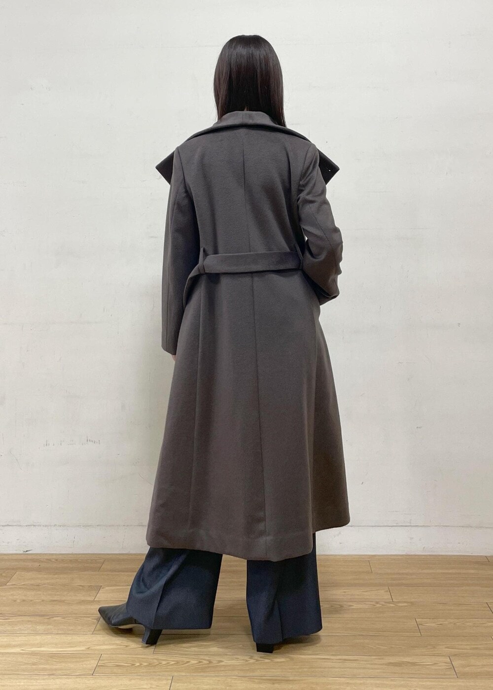 ブラック系のブーツ、ブラウン系のステンカラーコート、ブルー系のその他パンツを着用したレディースの秋コーディネートの7枚目の写真