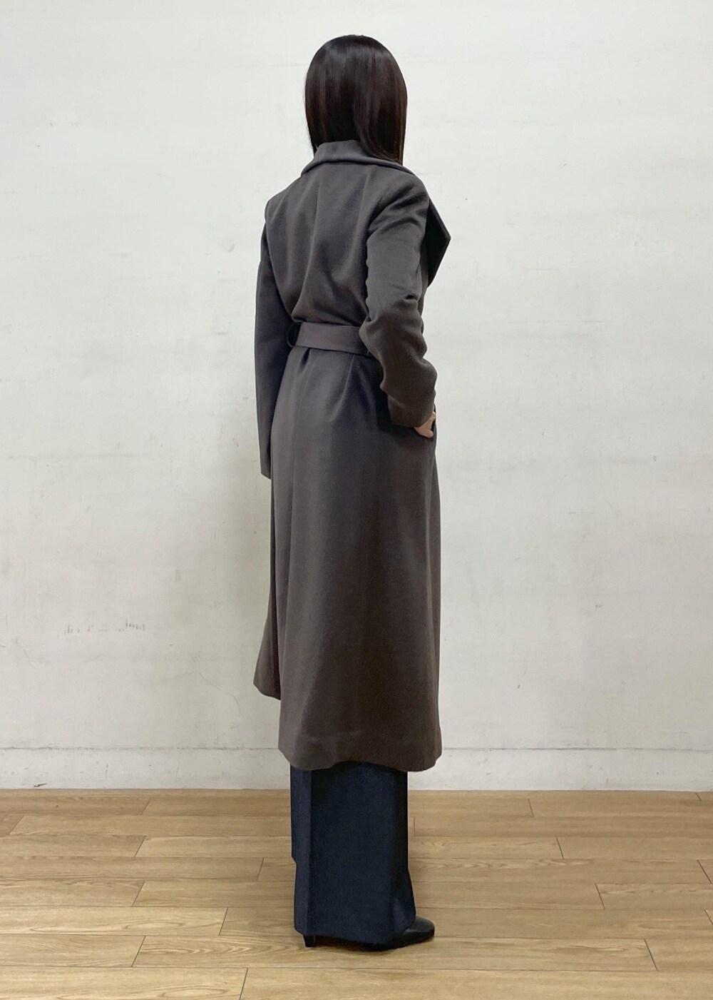 ブラック系のブーツ、ブラウン系のステンカラーコート、ブルー系のその他パンツを着用したレディースの秋コーディネートの6枚目の写真