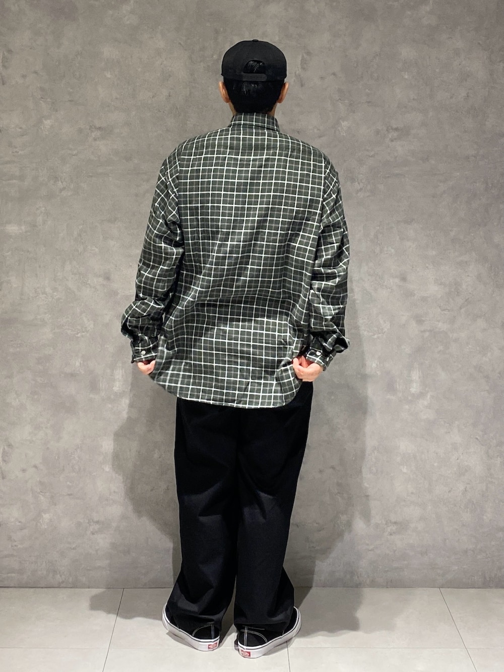 グリーン系のシャツ/ブラウス、ブラック系のチノパンツ、ブラック系のスニーカーを着用したメンズの秋コーディネートの2枚目の写真