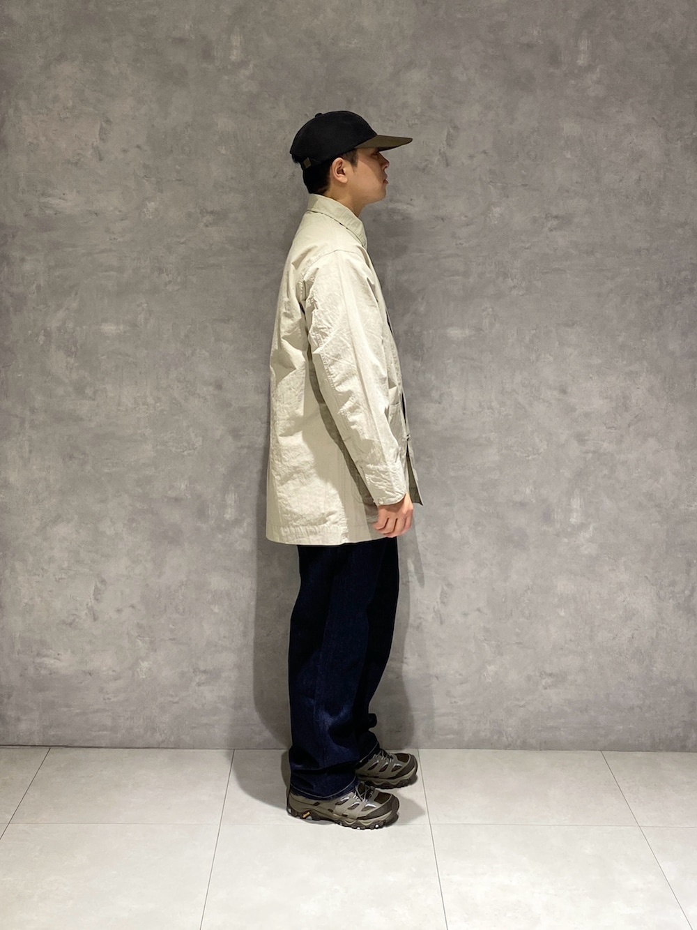 グレー系のカバーオール、ブルー系のデニムパンツを着用したメンズの冬コーディネートの2枚目の写真