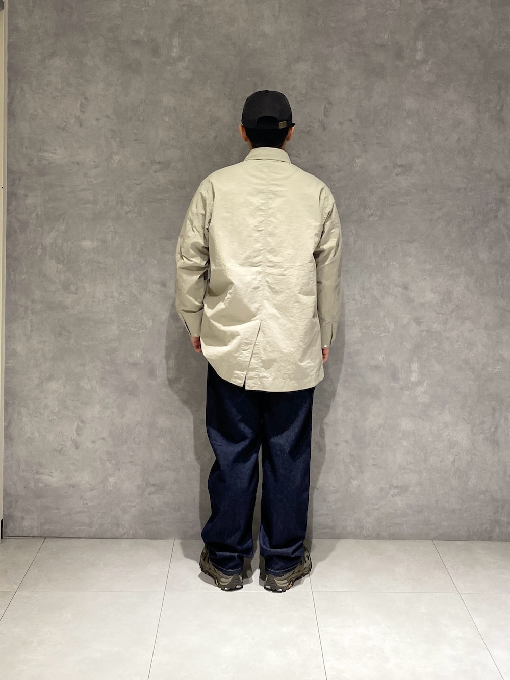 グレー系のカバーオール、ブルー系のデニムパンツを着用したメンズの冬コーディネートの3枚目の写真