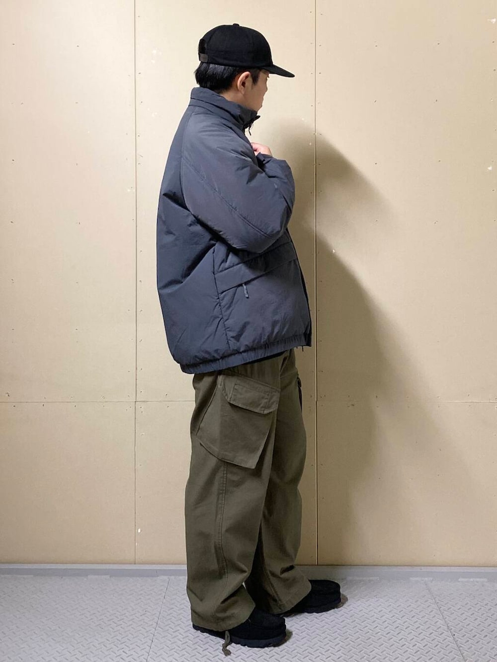 グリーン系のカーゴパンツ、ブラック系のブーツ、ブラック系のニット/セーターを着用したメンズの秋コーディネートの3枚目の写真