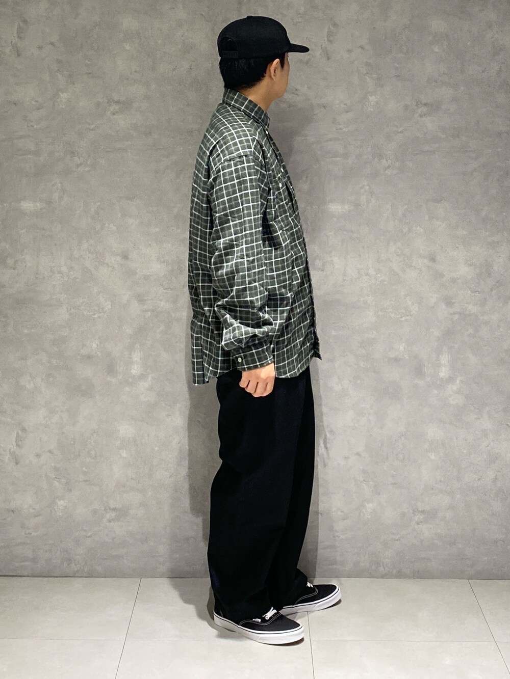 グリーン系のシャツ/ブラウス、ブラック系のチノパンツ、ブラック系のスニーカーを着用したメンズの秋コーディネートの3枚目の写真