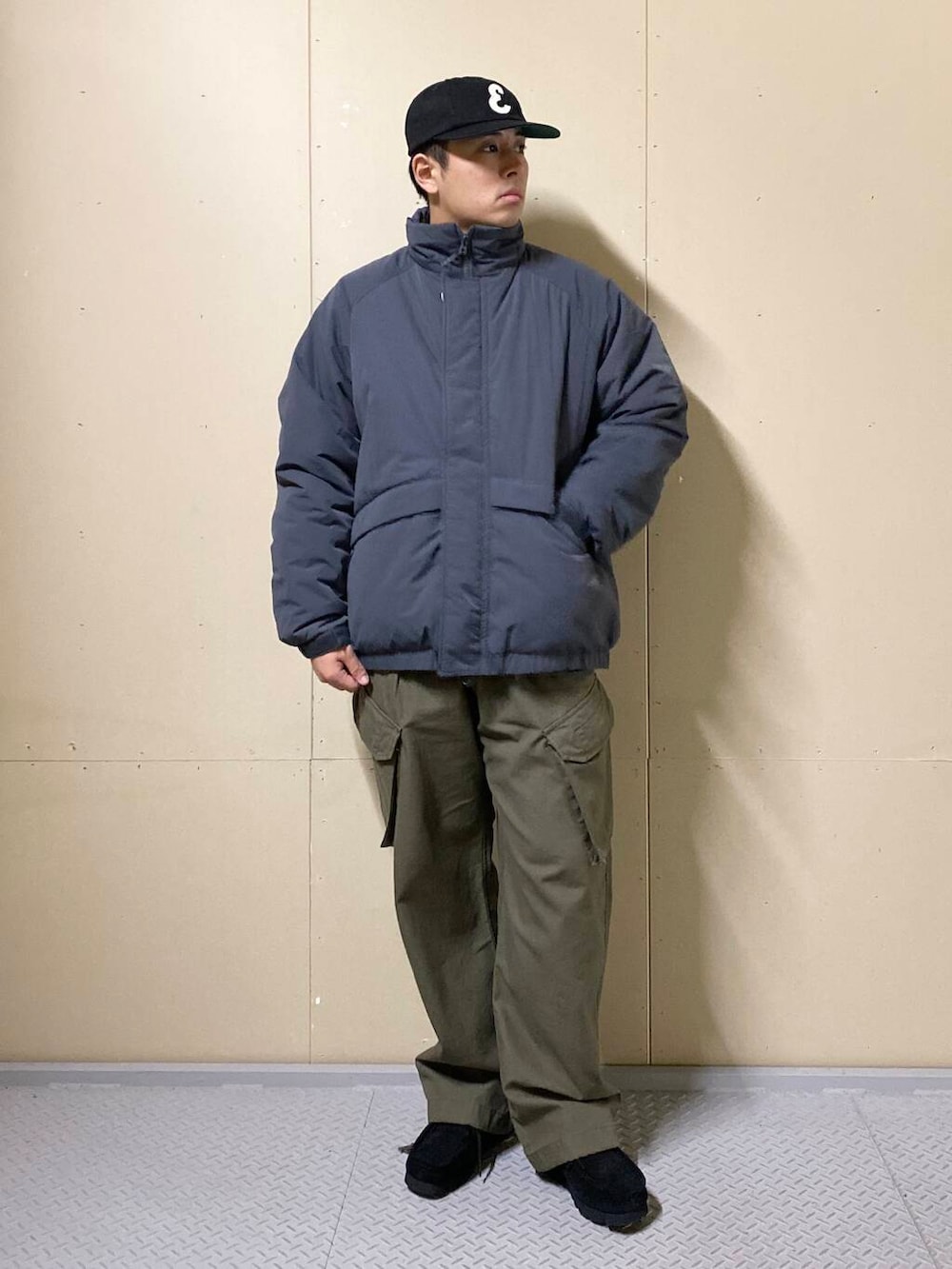 グリーン系のカーゴパンツ、ブラック系のブーツ、ブラック系のニット/セーターを着用したメンズの秋コーディネートの2枚目の写真