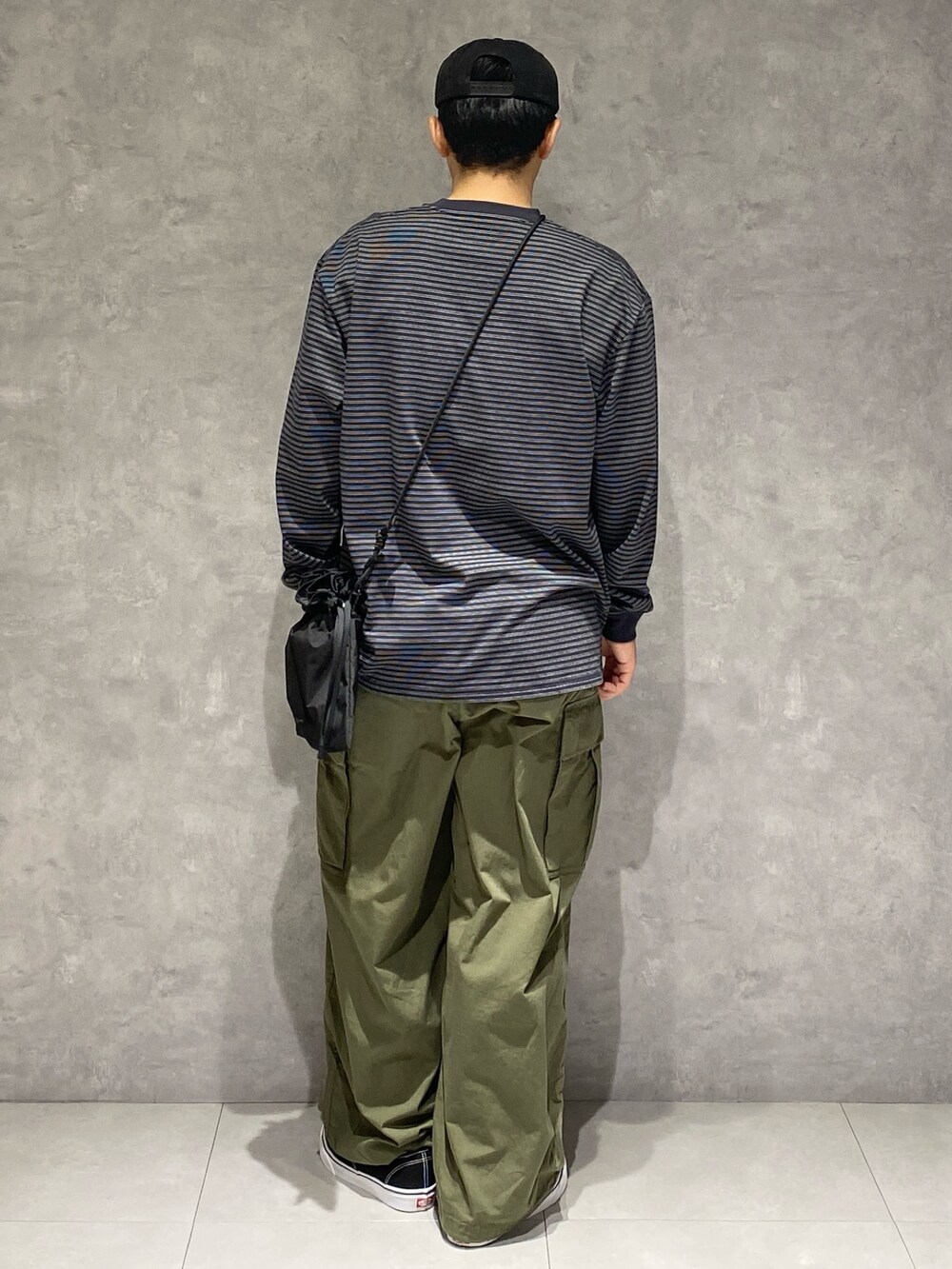 ブラック系のTシャツ/カットソー、ブラック系のショルダーバッグ、グリーン系のその他パンツを着用したメンズの秋コーディネートの2枚目の写真