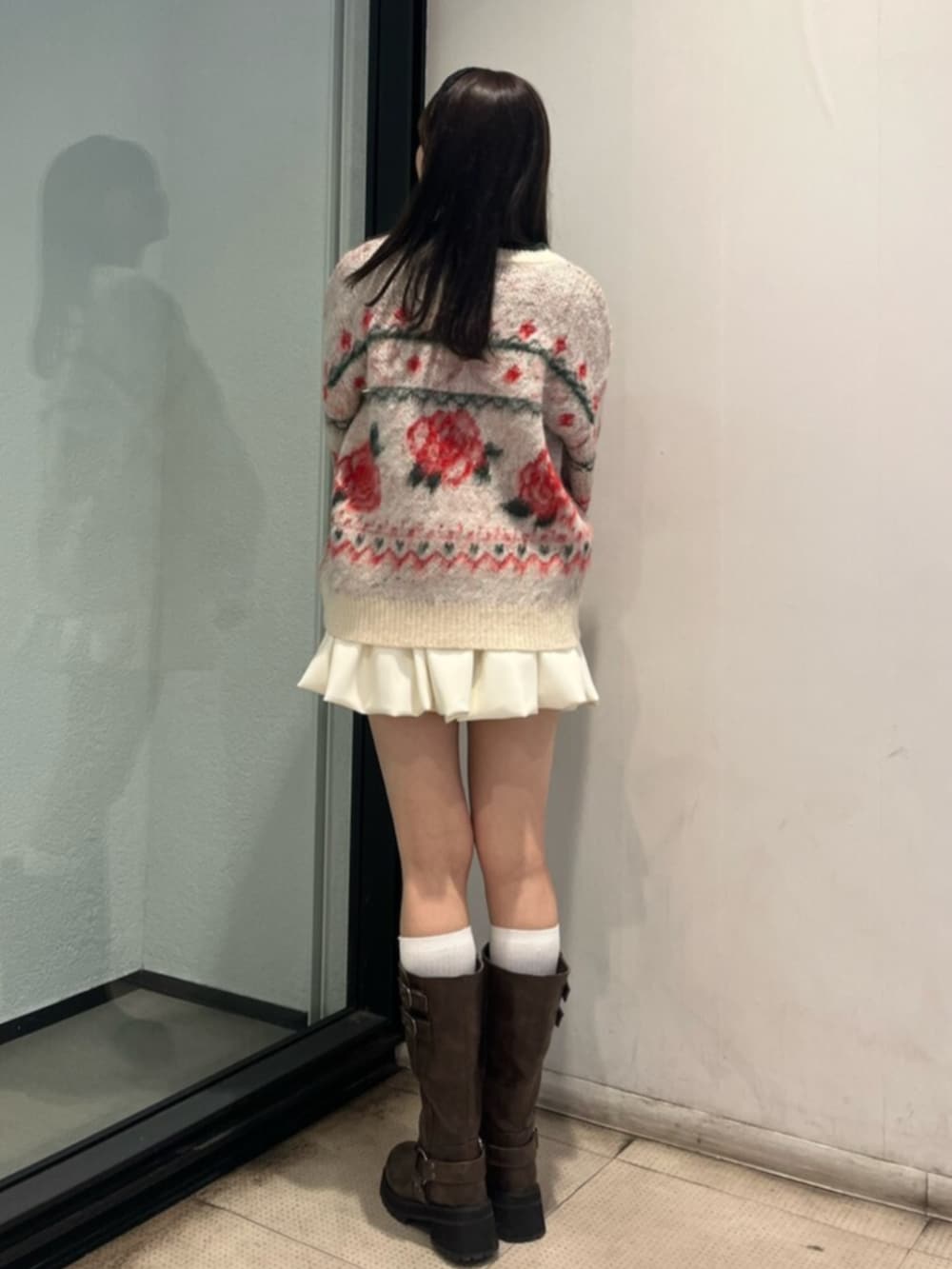 ブラウン系のブーツ、ホワイト系のニット/セーター、ホワイト系のスカートを着用したレディースの秋コーディネートの3枚目の写真