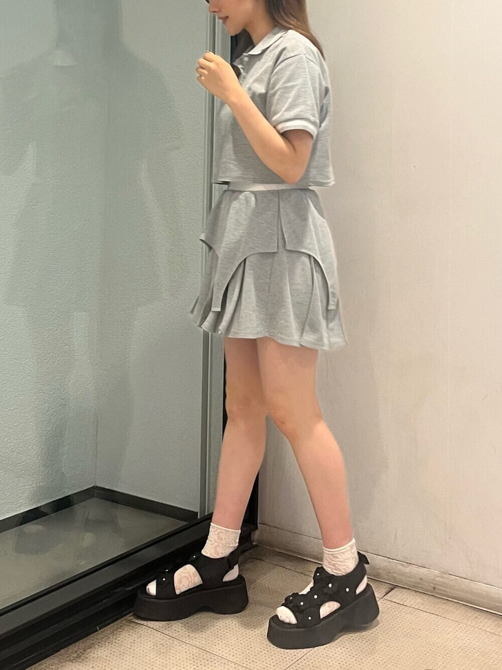 グレー系のワンピース、ブラック系のサンダルを着用したレディースの夏コーディネートの2枚目の写真