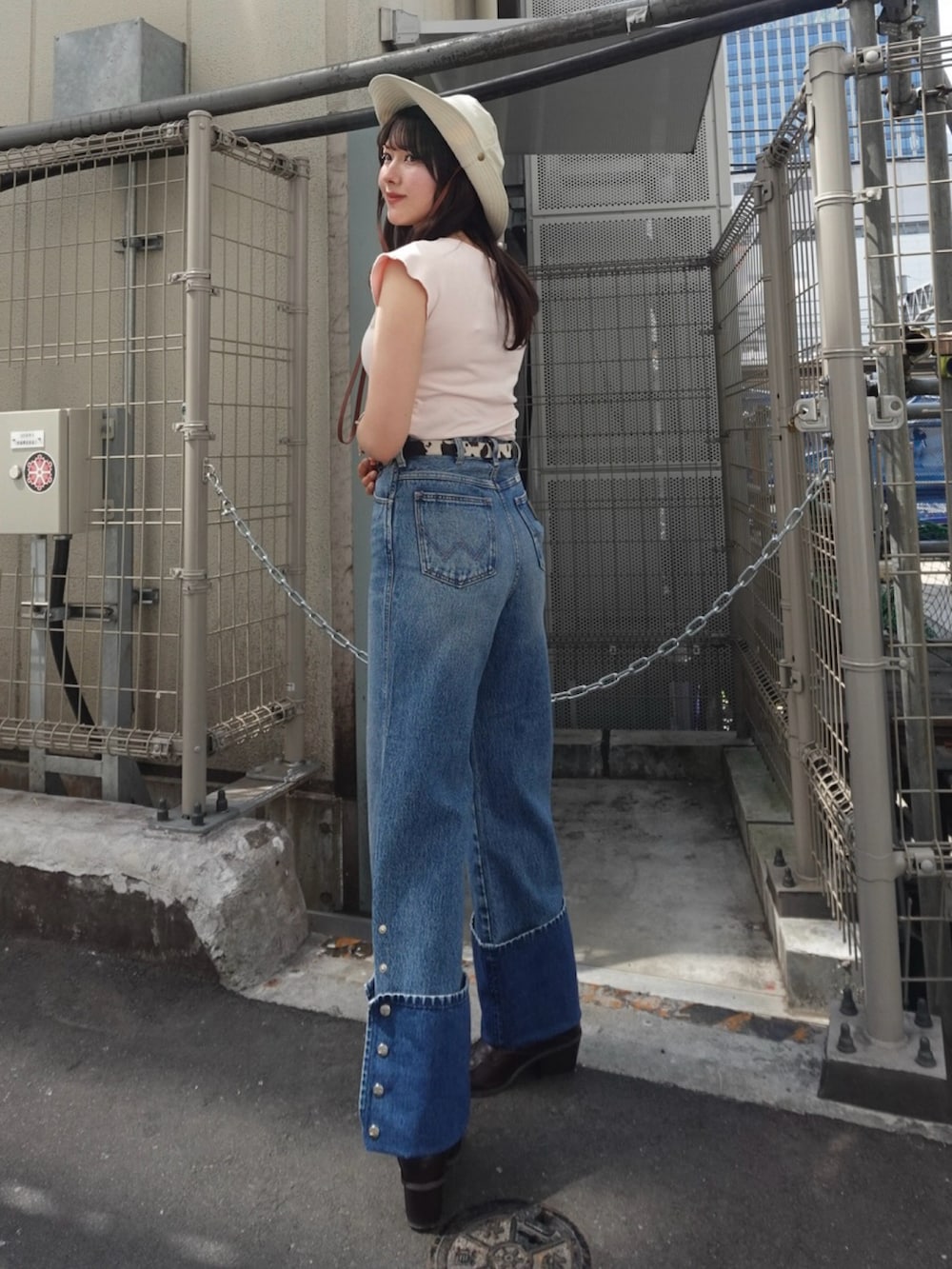 ピンク系のTシャツ/カットソー、ブラウン系のブーツ、ブルー系のデニムパンツを着用したレディースの春コーディネートの2枚目の写真