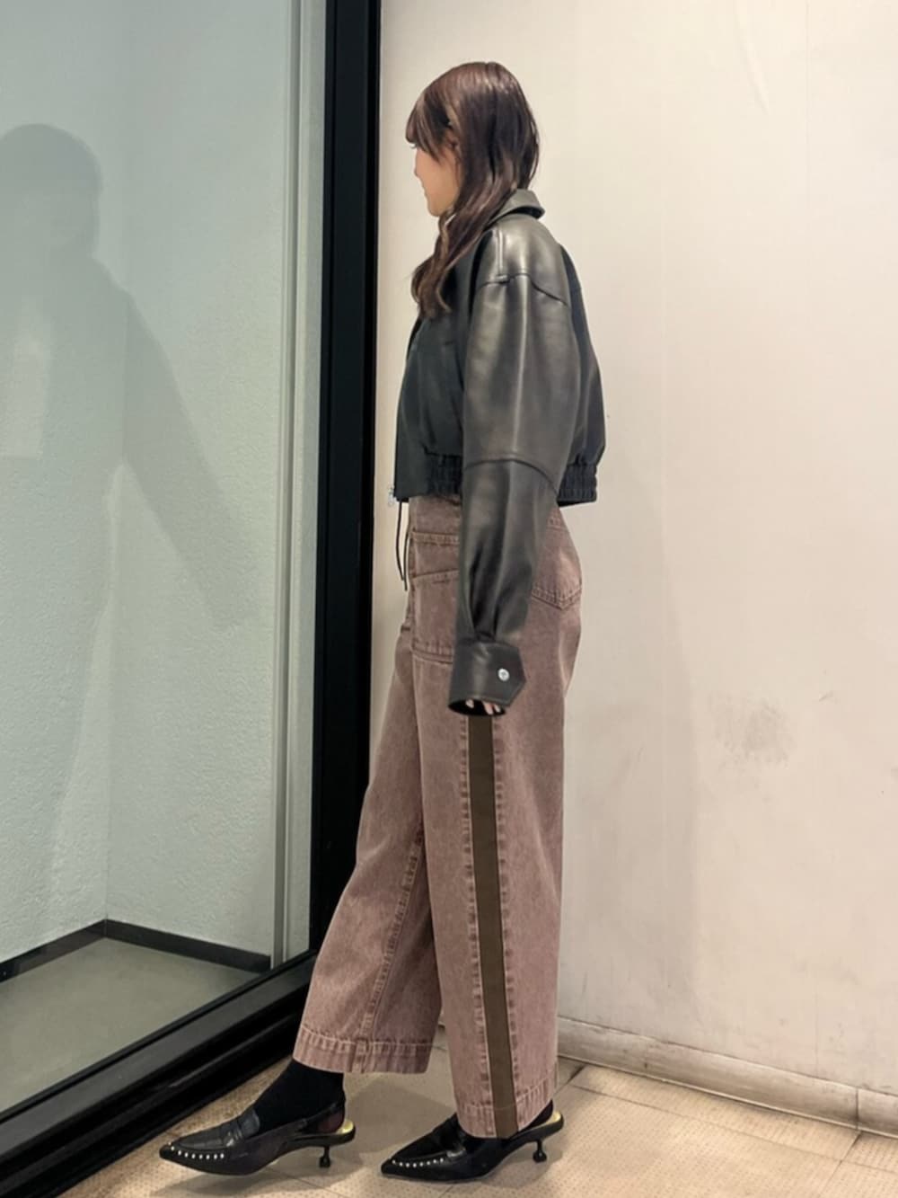 イエロー系のニット/セーター、ブラック系のサンダル、ブラック系のブルゾンを着用したレディースの春コーディネートの2枚目の写真