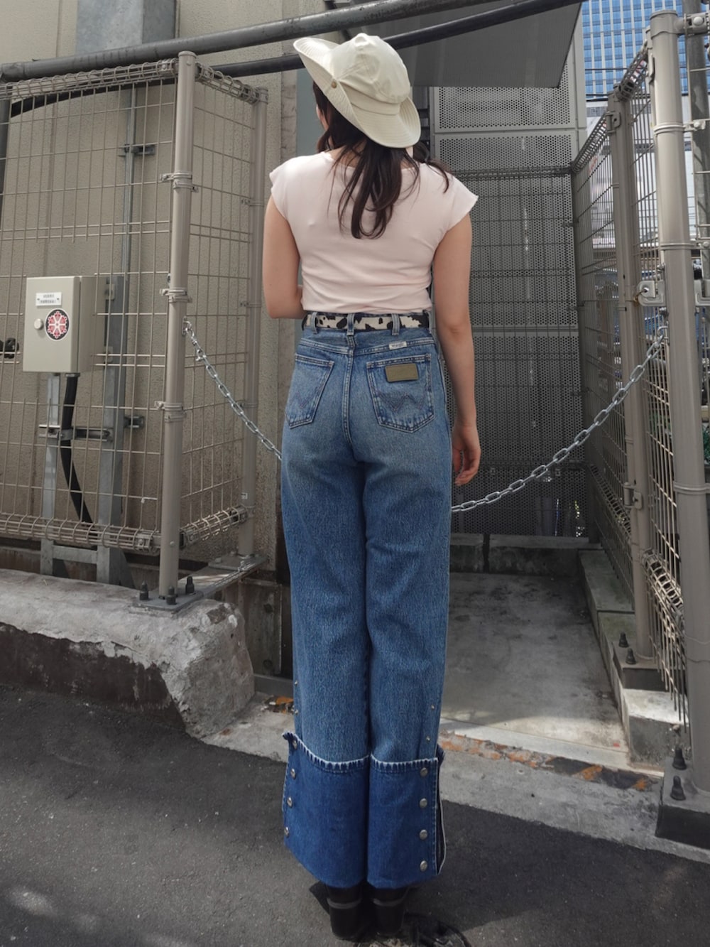 ピンク系のTシャツ/カットソー、ブラウン系のブーツ、ブルー系のデニムパンツを着用したレディースの春コーディネートの3枚目の写真